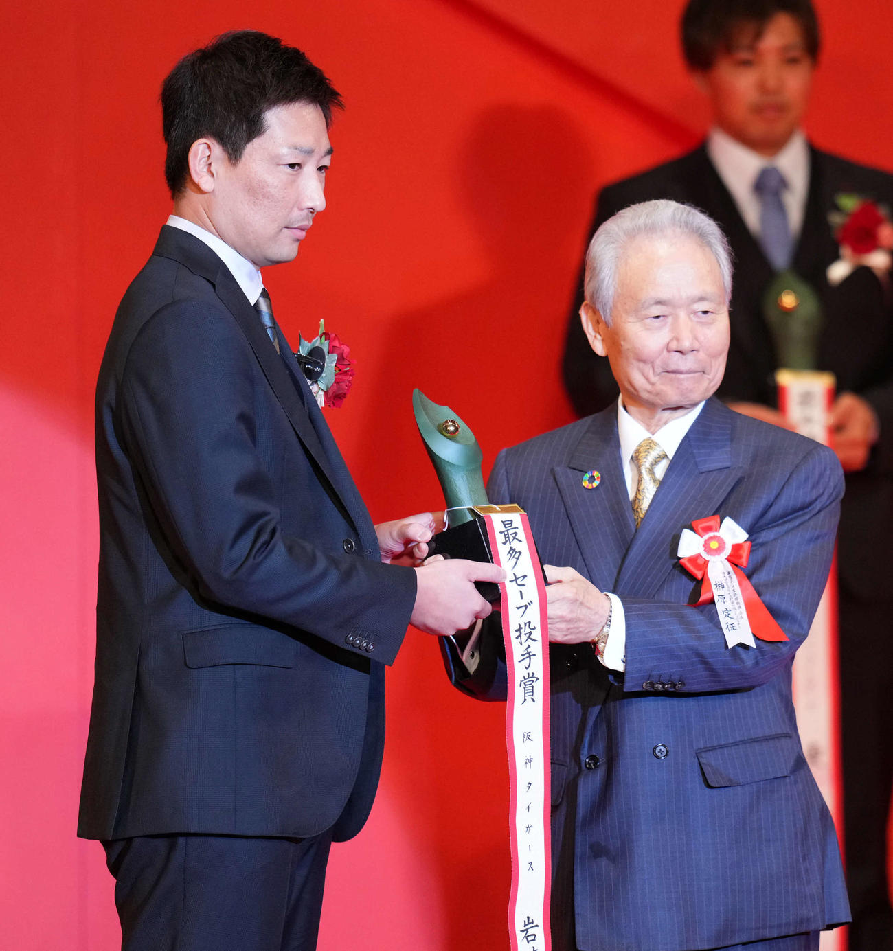 セリーグ最多セーブ投手賞を受賞した阪神岩崎。右は榊原コミッショナー（撮影・横山健太）