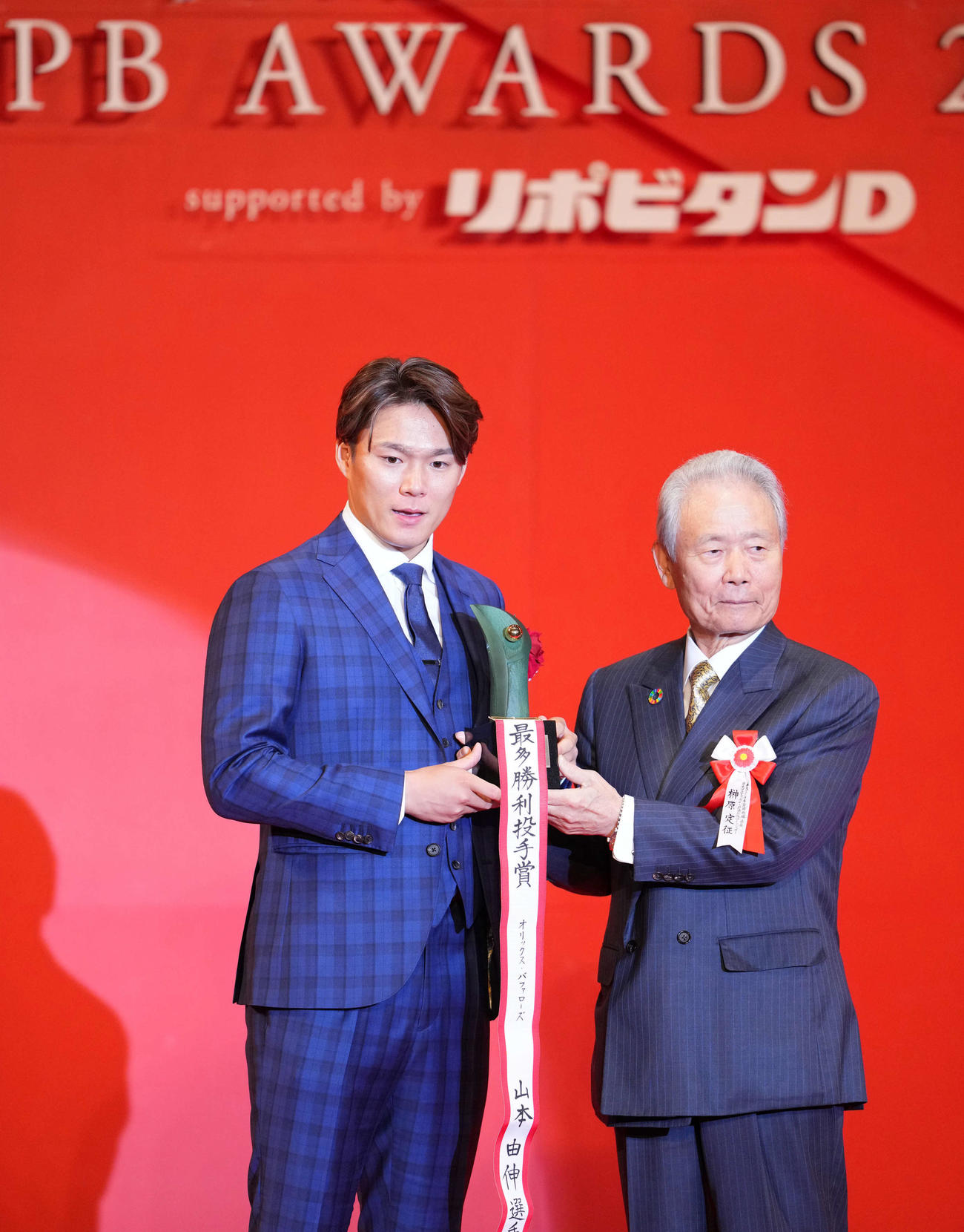 パリーグ投手4冠を達成し笑顔を見せるオリックス山本。右は榊原コミッショナー（撮影・横山健太）