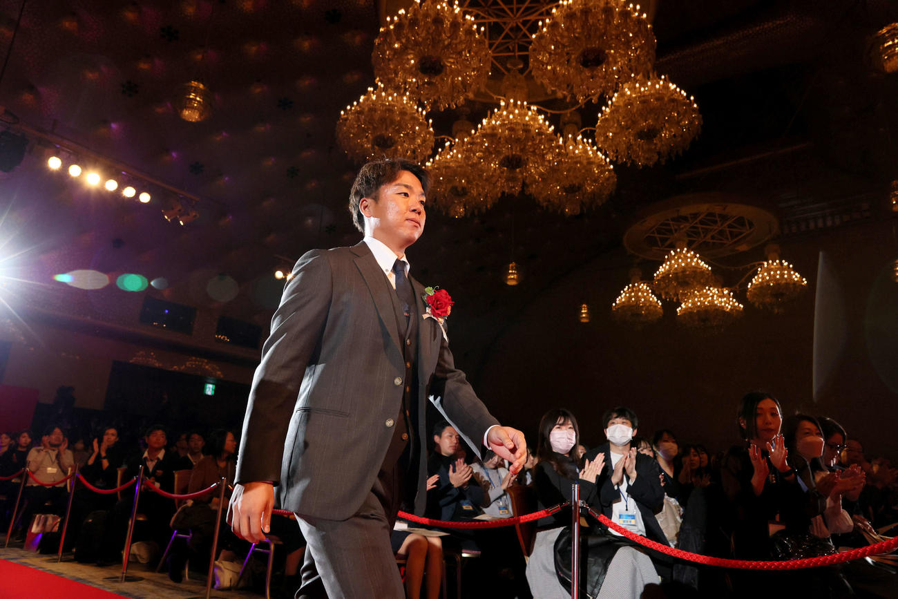 観客から拍手を受けながら壇上に向かう阪神村上（代表撮影）