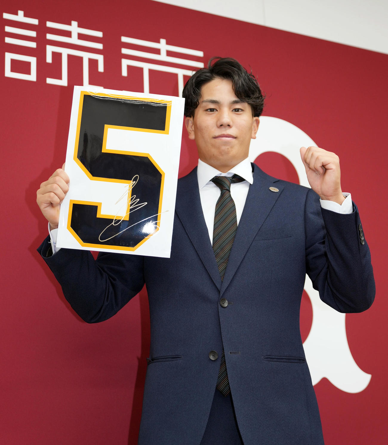 契約更改後、来季背番号「5」を手に記念撮影をする巨人門脇（撮影・狩俣裕三）
