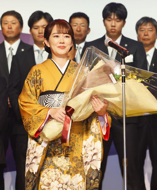 日本一・リーグ優勝祝賀会で花束を贈呈する歌手の丘みどり（撮影・藤尾明華）