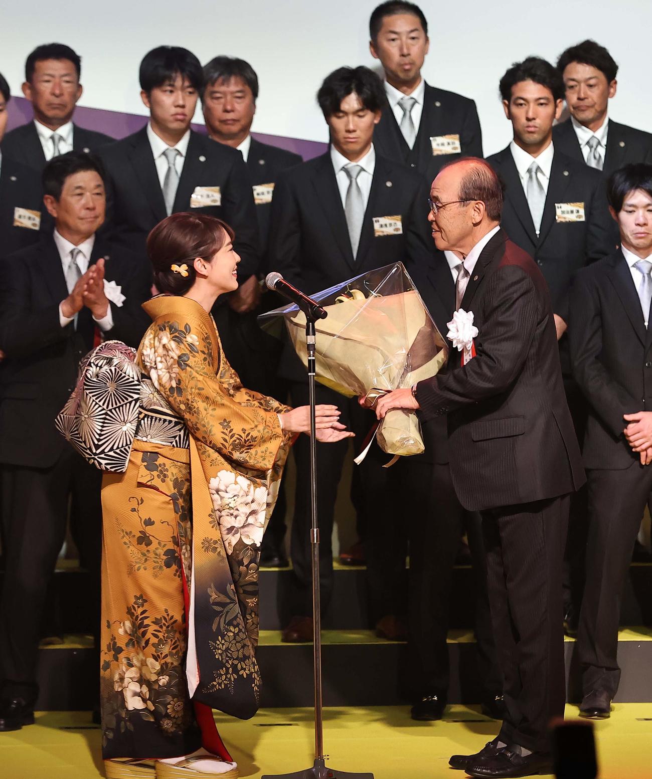 2023　阪神タイガース日本一・リーグ優勝祝賀会で歌手の丘みどり（左）から花束を受け取る岡田監督（撮影・上田博志）