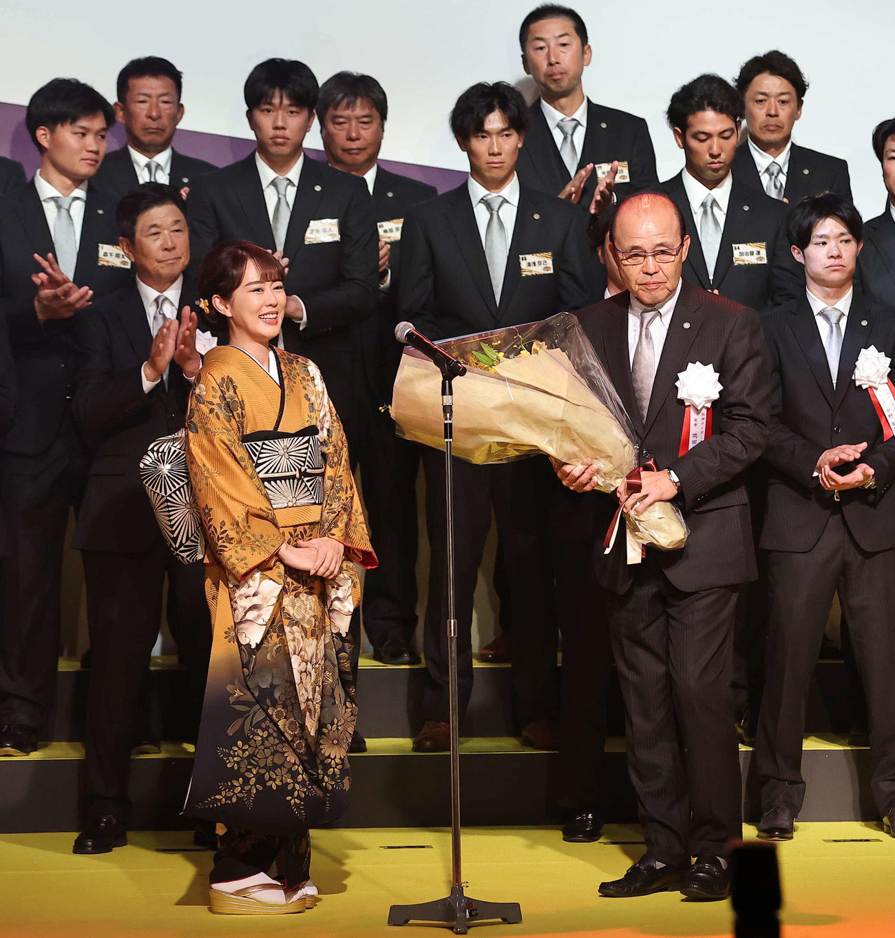 2023　阪神タイガース日本一・リーグ優勝祝賀会で歌手の丘みどり（左）から花束を受け取る岡田監督（撮影・上田博志）