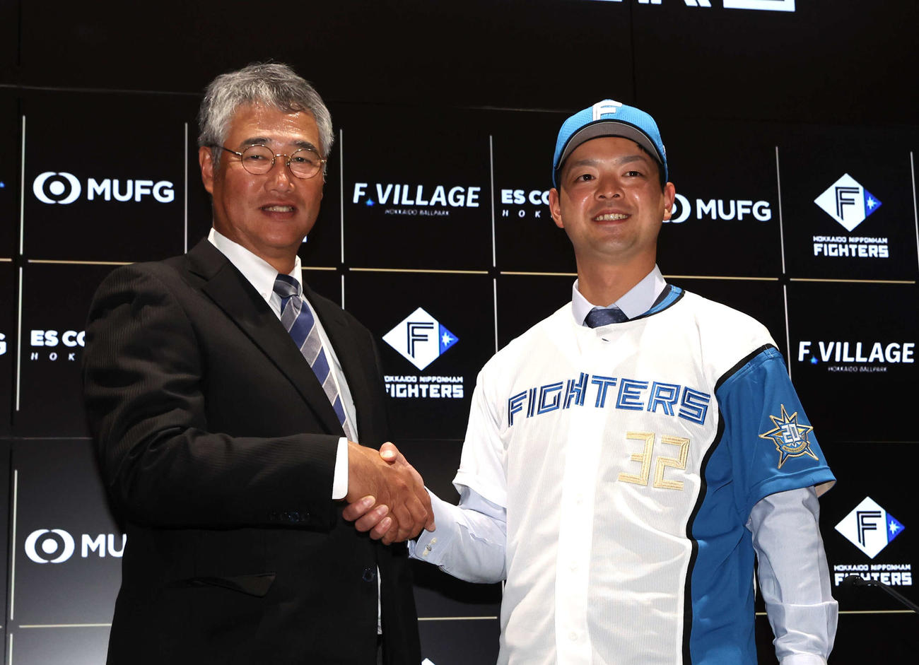 日本ハムへの移籍会見で木田GM代行（左）と握手する黒木（撮影・黒川智章）