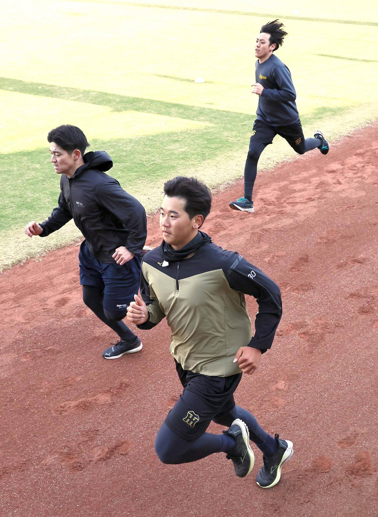 門別（中央）は伊藤稜（左）と小川と外野をダッシュする（撮影・上田博志）