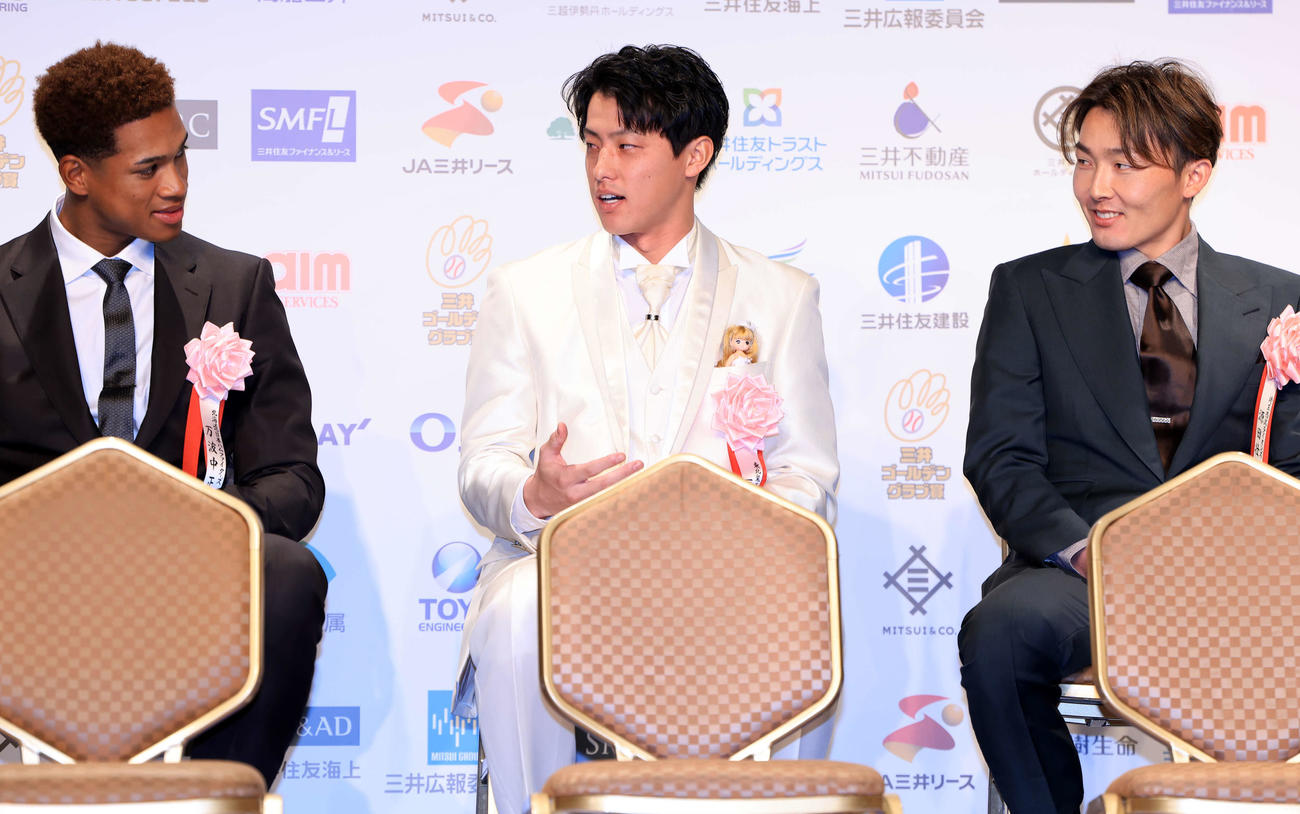 三井ゴールデン・グラブ賞表彰式に白いスーツで登場した楽天辰己（中央）は、「新婦」の人形を胸ポケットに入れ、日本ハム万波（左）、西武源田に説明する（撮影・浅見桂子）