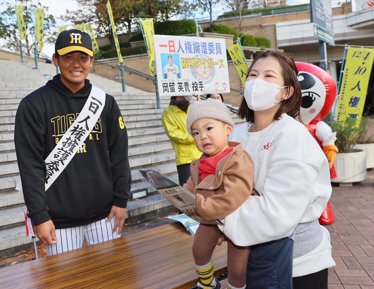 1日擁護委員を勤めた岡留は啓発物品を配り笑顔を見せる（撮影・上田博志）