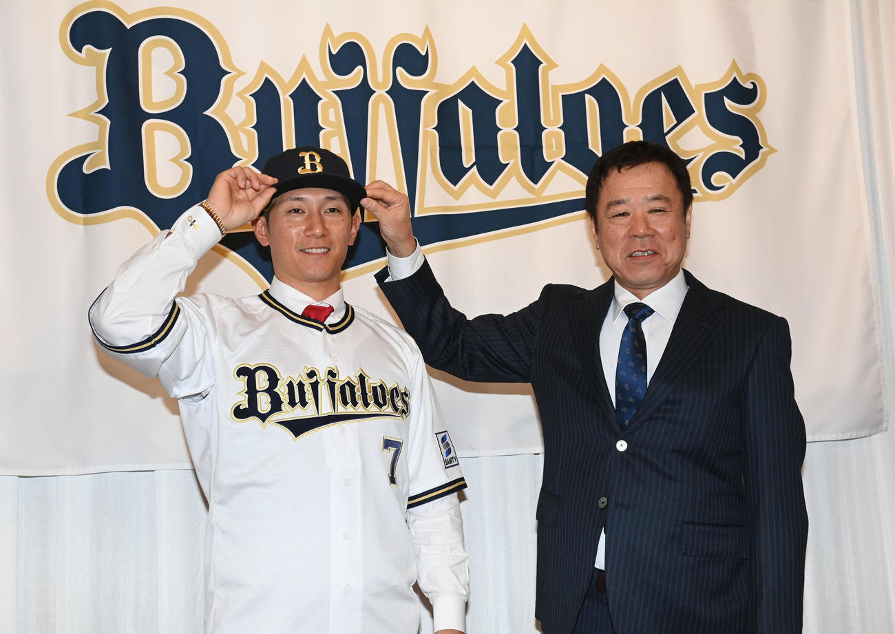 オリックスへの入団会見を行い、福良GM（右）から帽子をかぶせてもらう西川（撮影・和賀正仁）