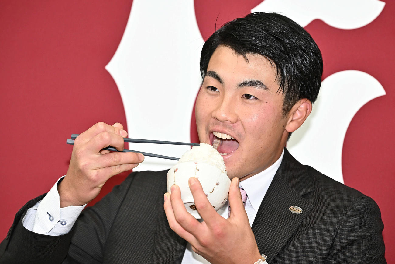 契約更改を終え米どころ新潟出身の巨人菊地は、大盛りご飯を手に記念撮影する（撮影・滝沢徹郎）