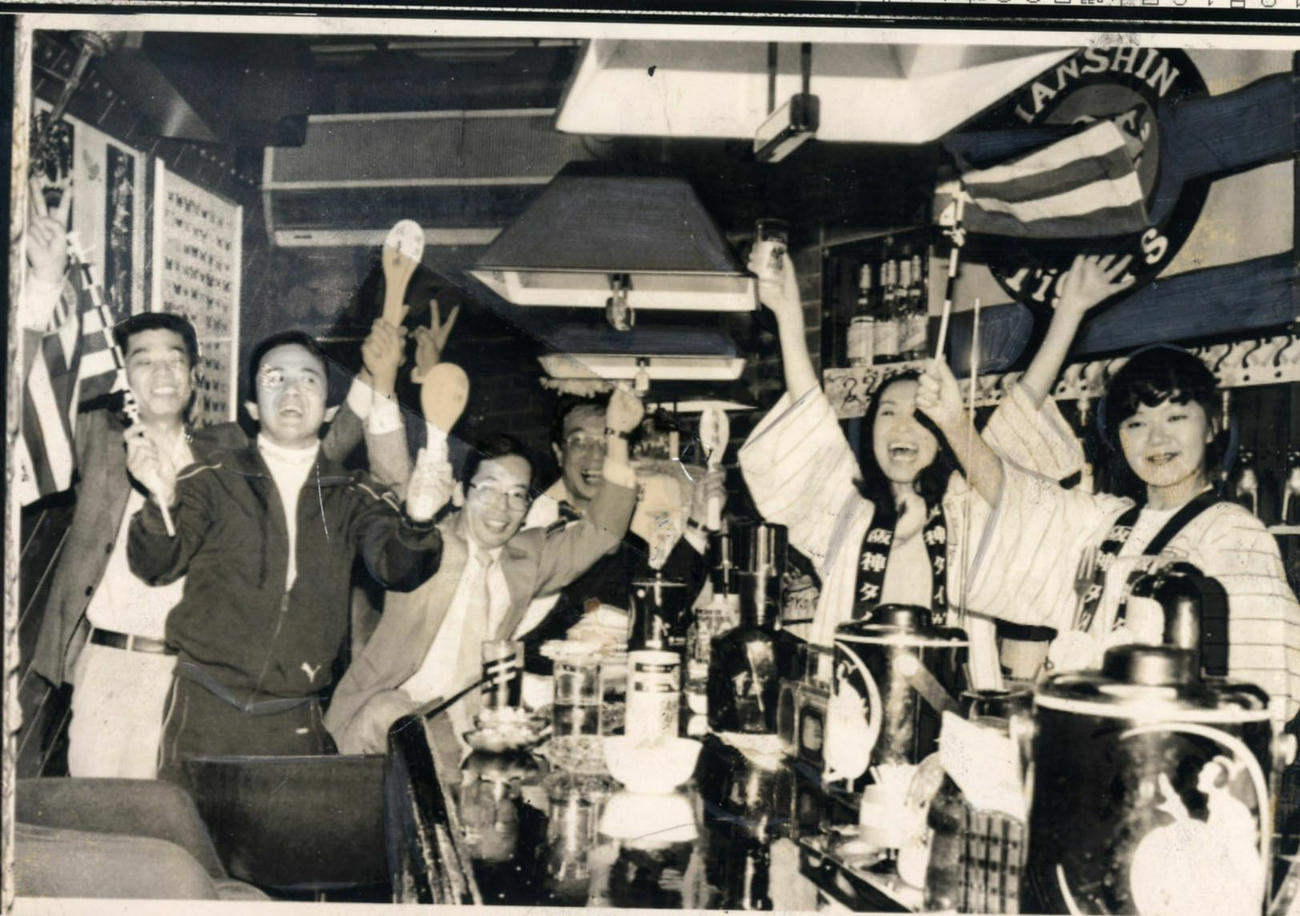 21年ぶりにリーグ優勝を飾った阪神に、応援のため居酒屋に大集合のトラキチはバンザイをして喜ぶ（1985年撮影）
