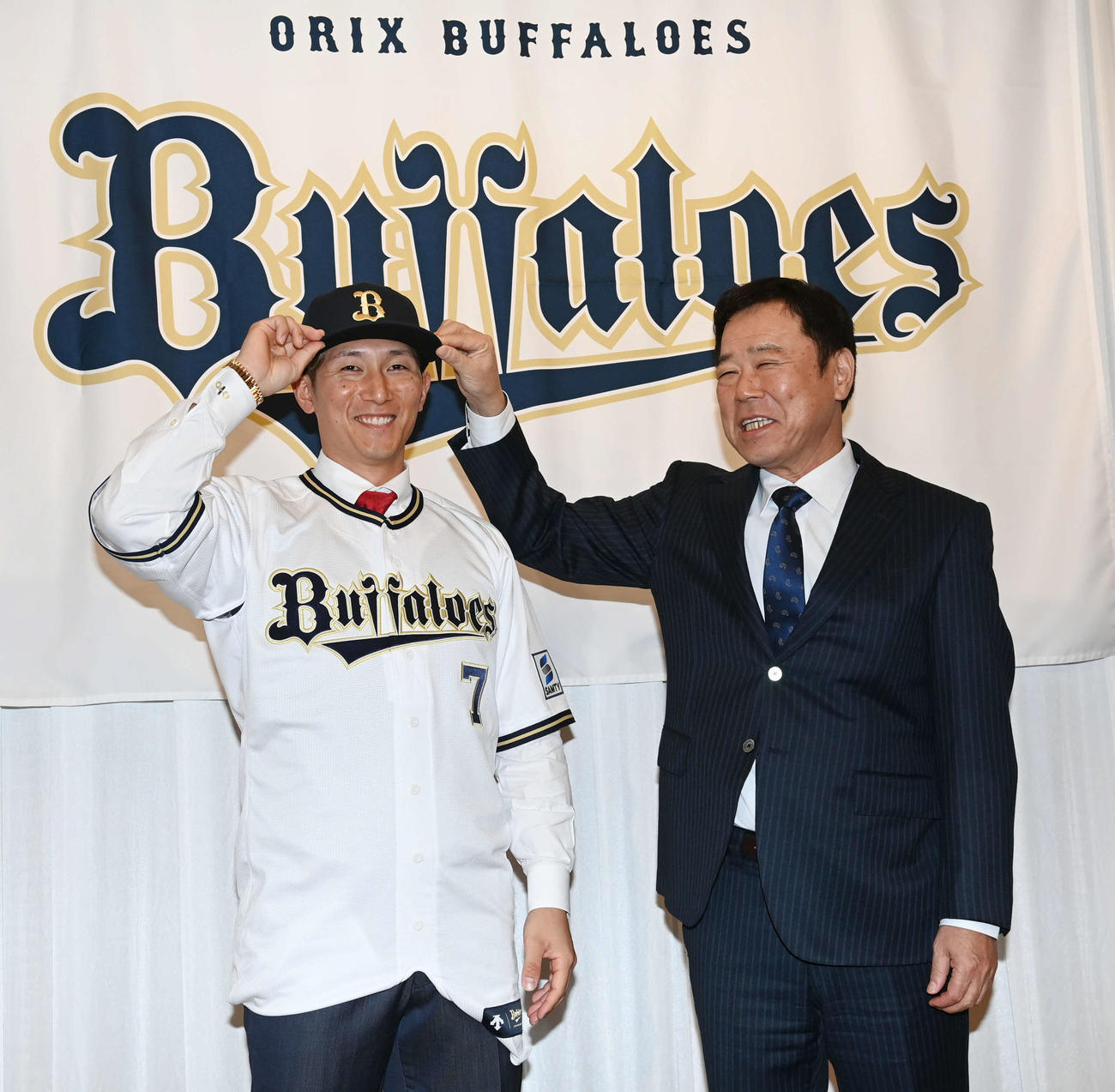 オリックスへの入団会見を行い、福良GM（右）から帽子をかぶせてもらう西川（撮影・和賀正仁）