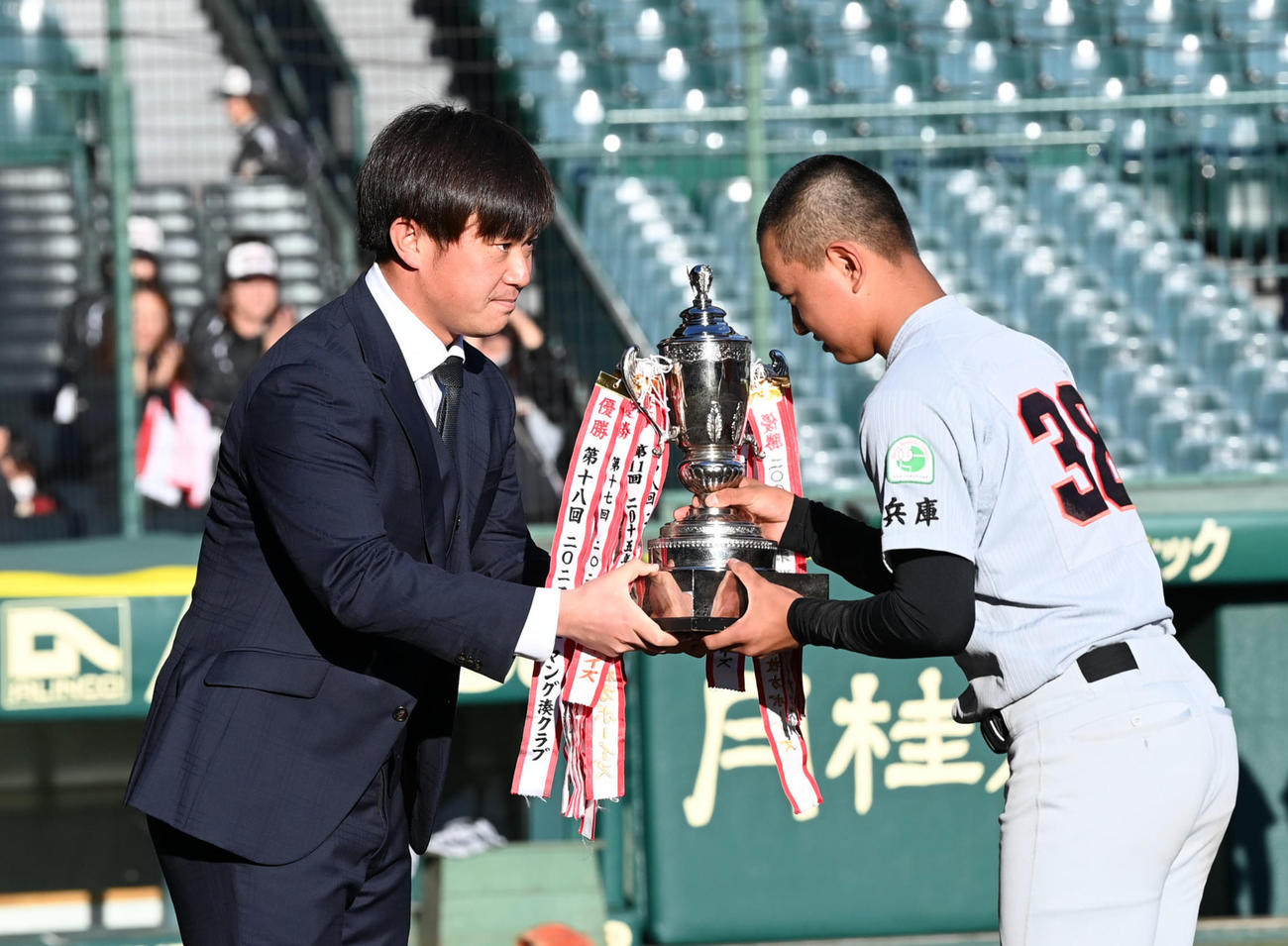 タイガースカップ表彰式で兵庫夢前に優勝カップを手渡す桐敷（撮影・前岡正明）