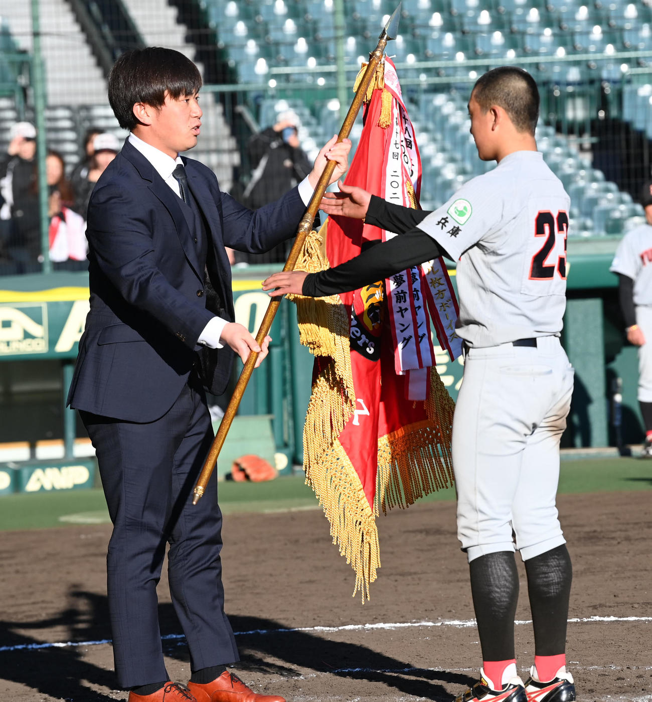 タイガースカップ表彰式で兵庫夢前に優勝旗を手渡す桐敷（撮影・前岡正明）