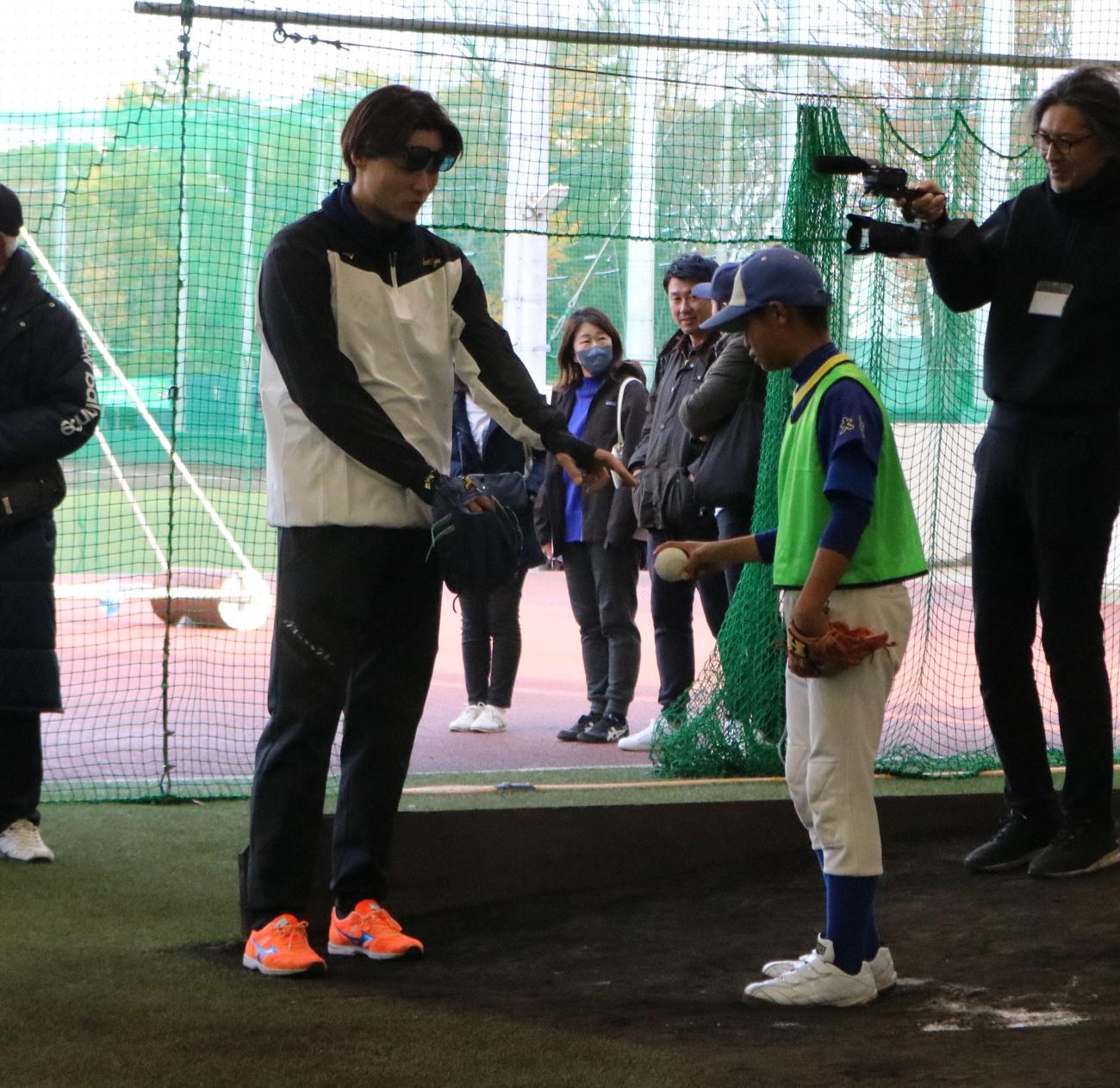 日本ハム山崎福也投手が野球教室で小学生に投球指導する（撮影・林亮佑）＝2023年12月2日、大阪学院大総合スポーツフィールド野球場