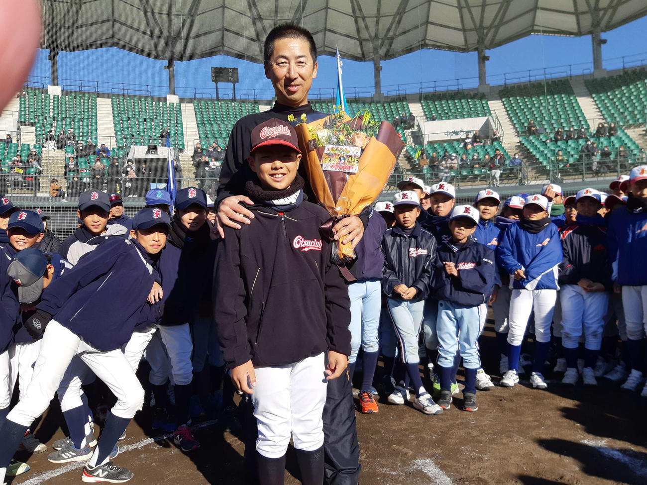 大津少年野球クラブ主将の碧木颯河（あおき・そうが）君から花束を送られて笑顔の阪神今岡コーチ（撮影・寺尾博和）