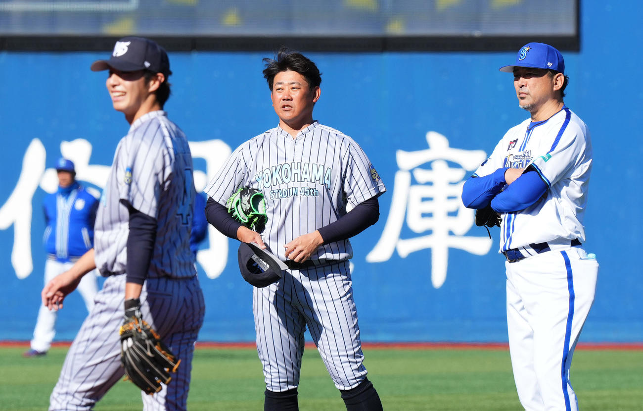 試合前、斎藤氏（右）と話す松坂氏。左は守備練習をする度会（撮影・菅敏）