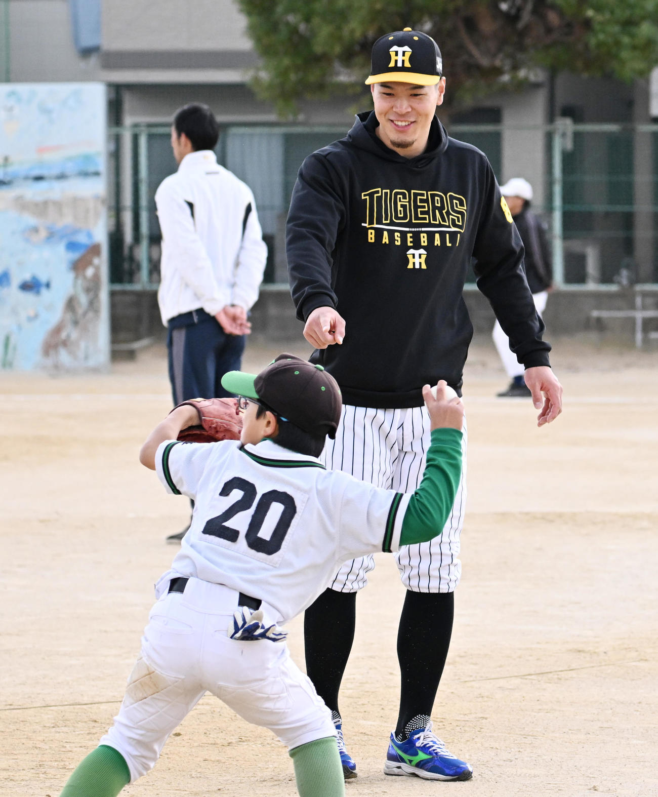 野球教室のノックでナイスプレーをみせた選手に笑顔をみせる阪神佐藤輝（撮影・清水貴仁）
