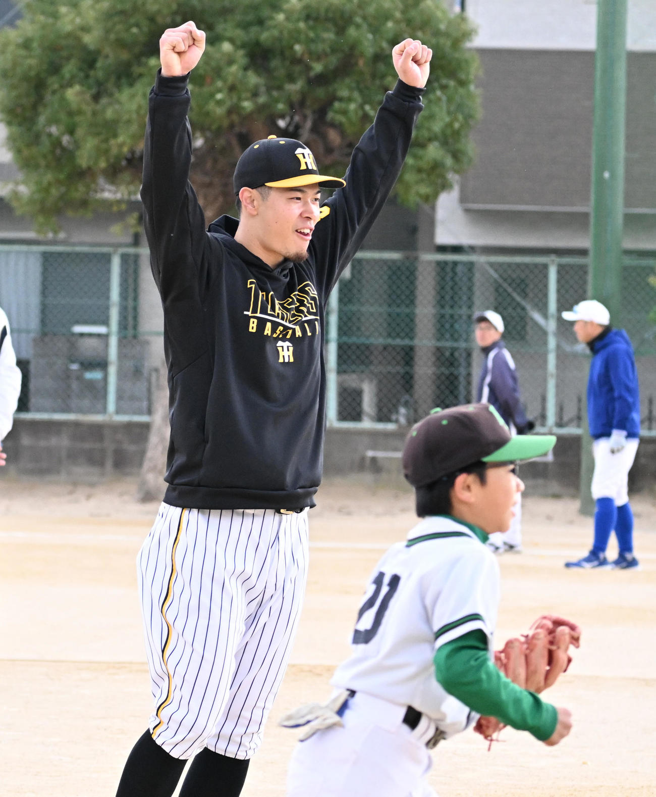 野球教室のノックでナイスプレーをみせた選手に両手を突き上げる阪神佐藤輝（撮影・清水貴仁）