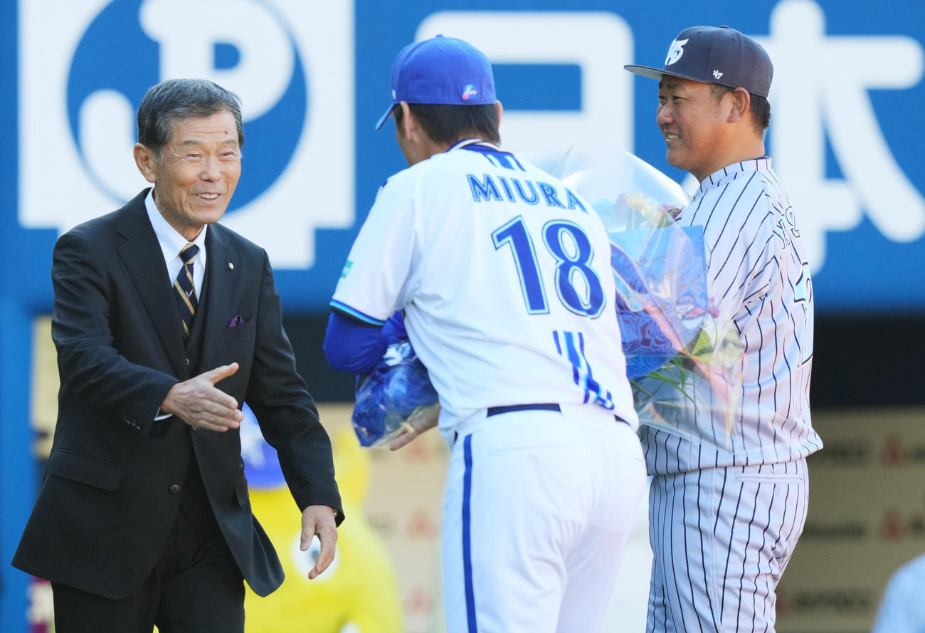 オープニングセレモニーで横浜・渡辺監督（左）から花束を受け取り、笑顔を見せる松坂氏。前方は三浦監督（撮影・菅敏）