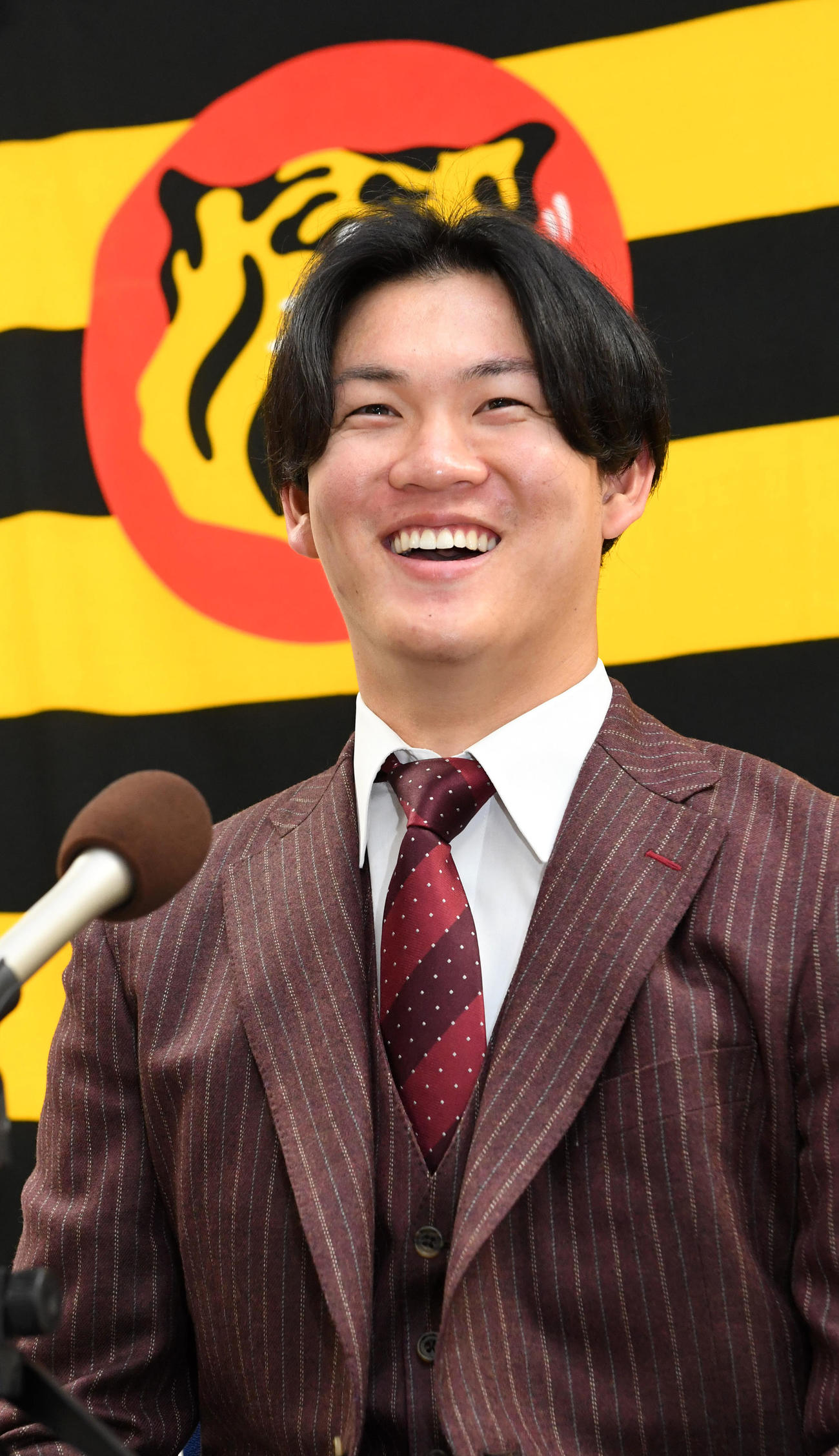 大幅アップで契約更改を終え、笑顔で会見する及川（撮影・前岡正明）