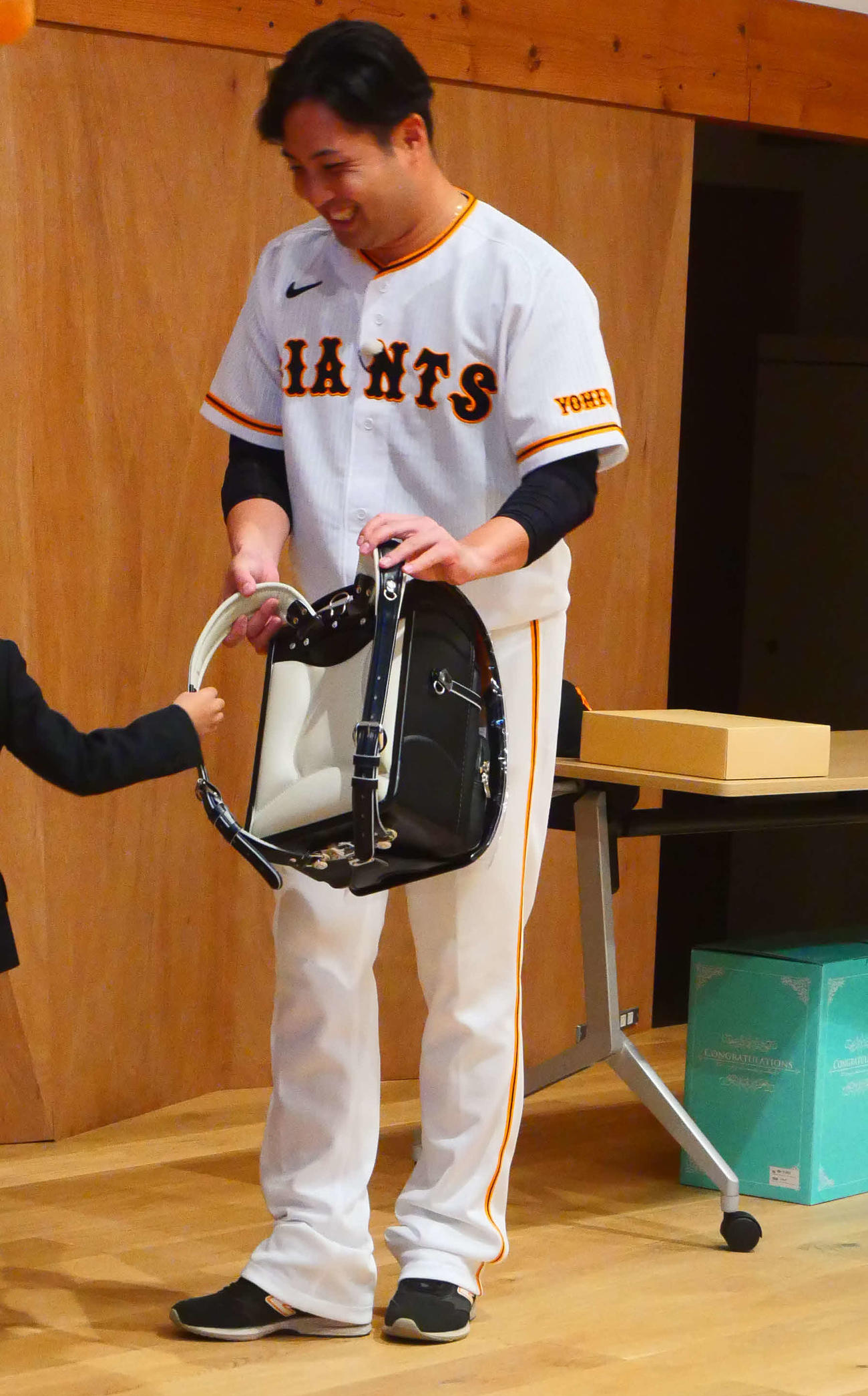 笑顔で児童にランドセルをプレゼントする巨人今村（撮影・上田悠太）