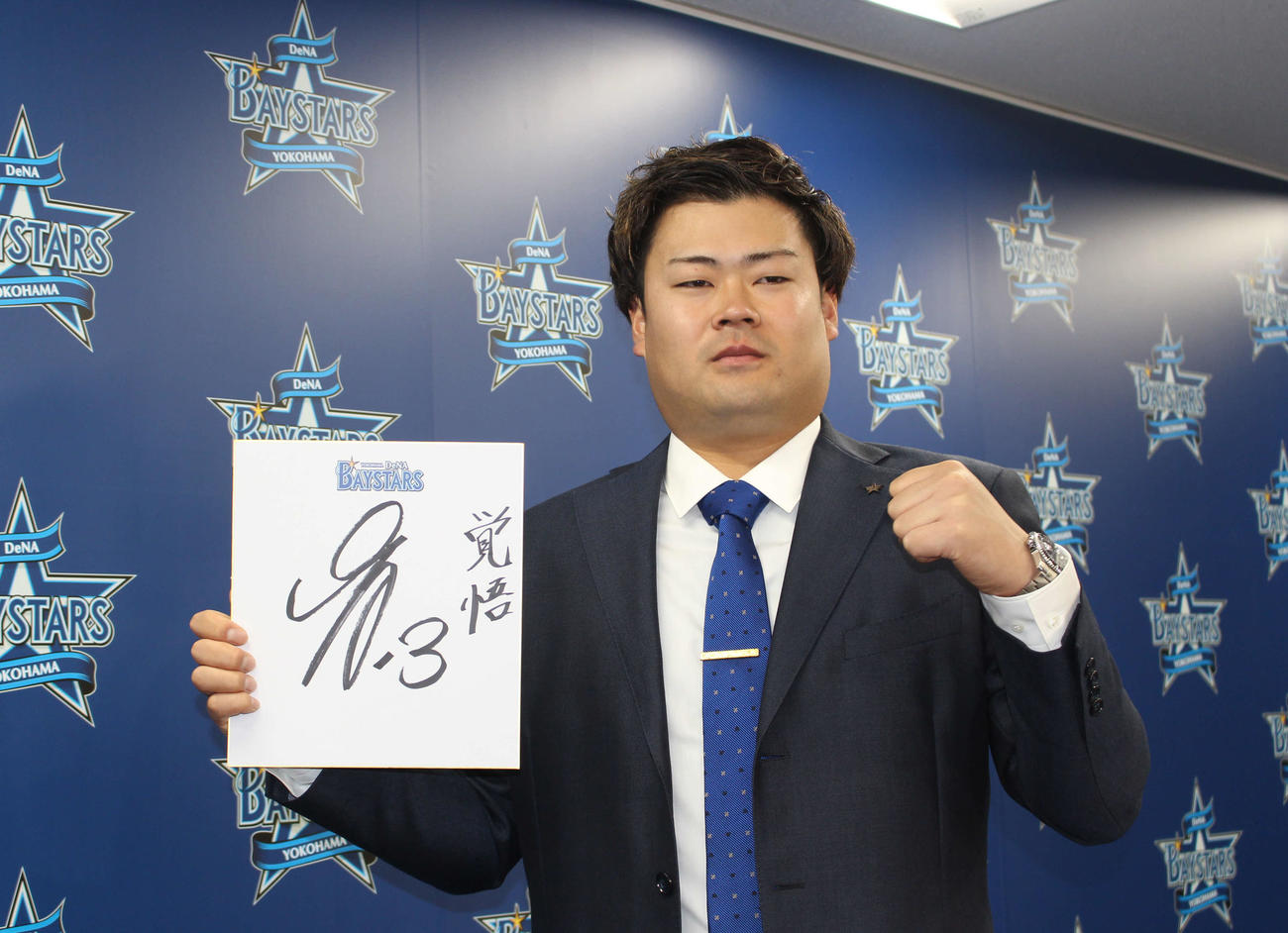 「覚悟」と記した色紙を手に、気合の入った表情でポーズを決めるDeNA伊勢（撮影・久保賢吾）
