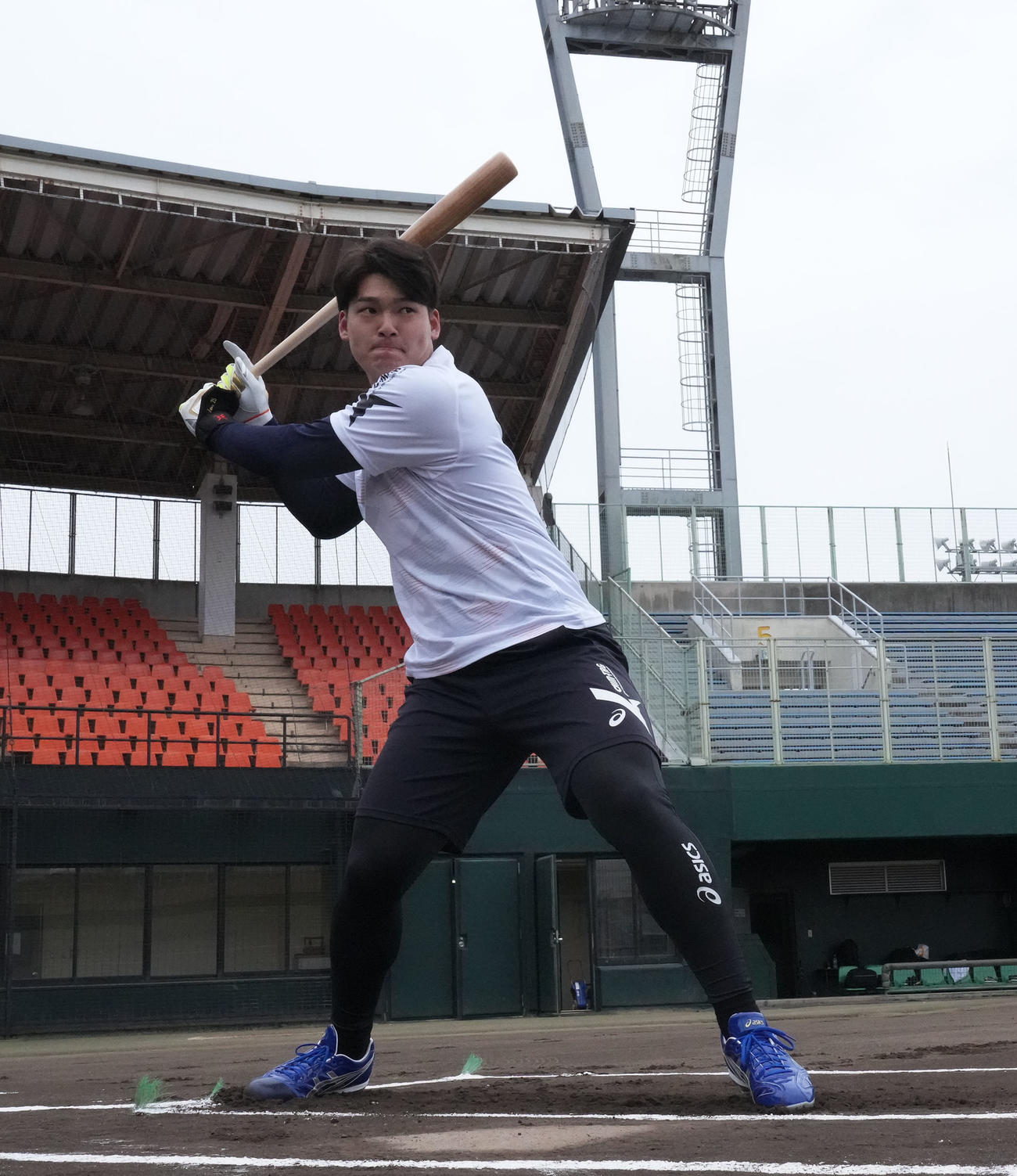 用具提供を受けるアシックス社の撮影に臨み打撃を披露する石川昂（撮影・森本幸一）