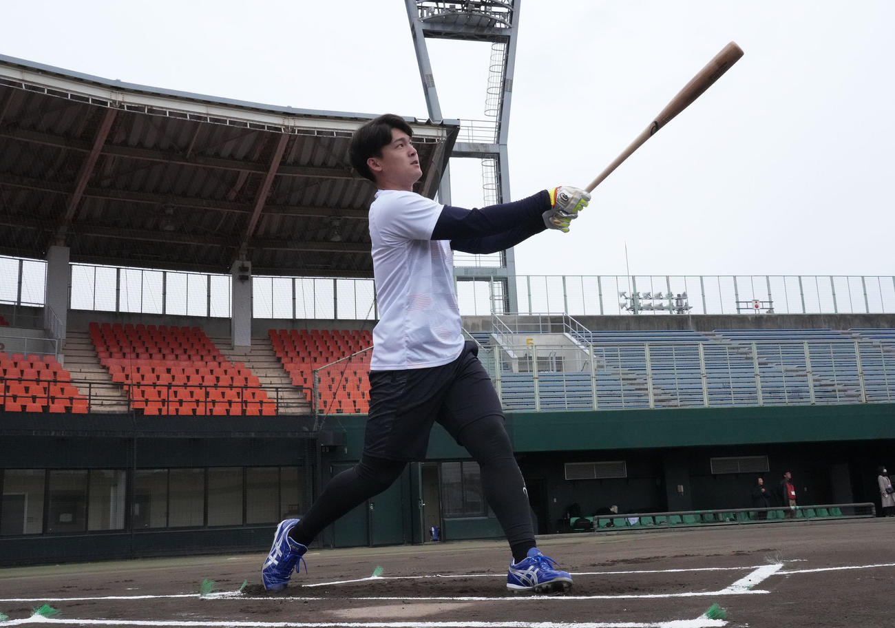 用具提供を受けるアシックス社の撮影に臨み打撃を披露する石川昂（撮影・森本幸一）