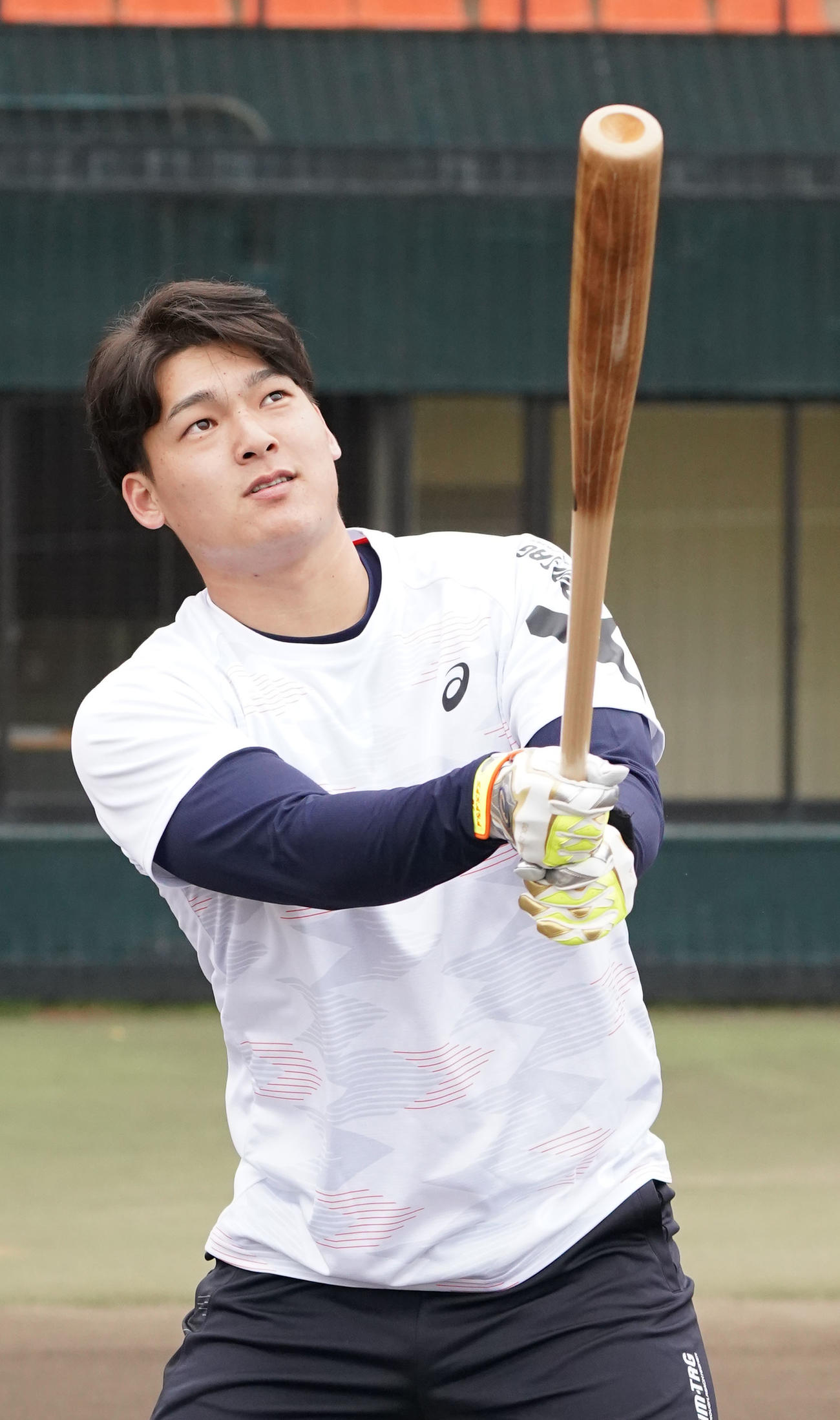用具提供を受けるアシックス社の撮影に臨み打撃を披露する石川昂（撮影・森本幸一）