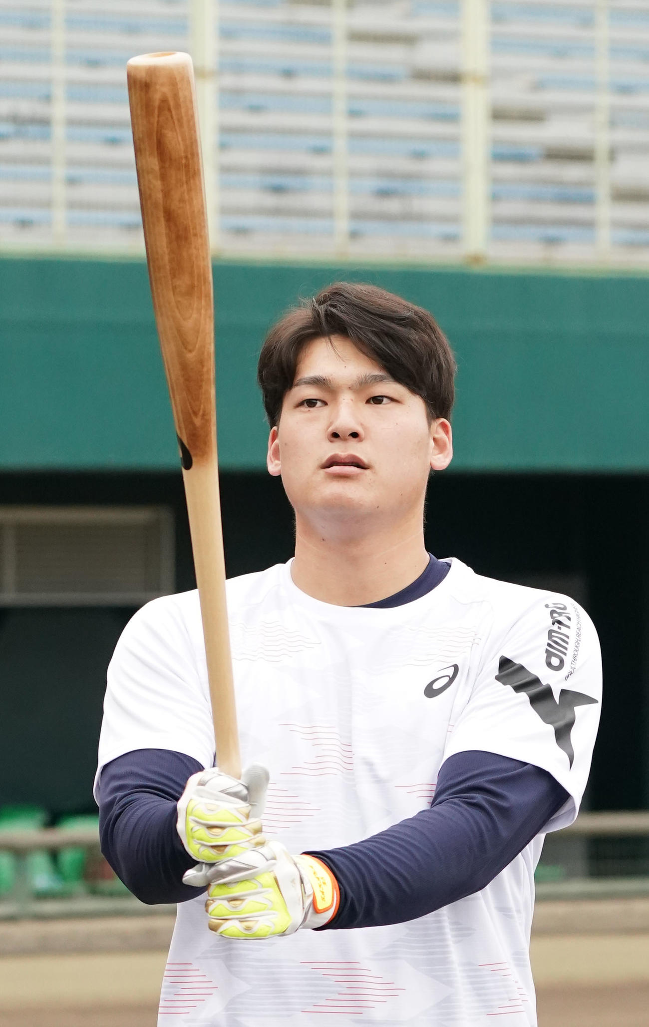 用具提供を受けるアシックス社の撮影に臨み打撃を披露する石川昂（撮影・森本幸一）