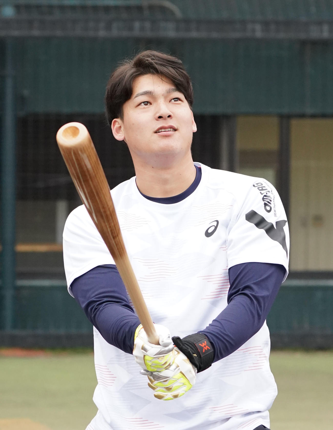 用具提供を受けるアシックス社の撮影に臨み打撃を披露する石川昂（撮影・森本幸一）