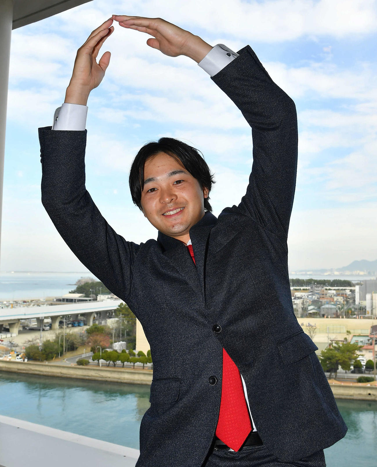 増額の川瀬は来季背番号を0に変更することを希望し、青空を背に笑顔で0ポーズを決める（撮影・岩下翔太）