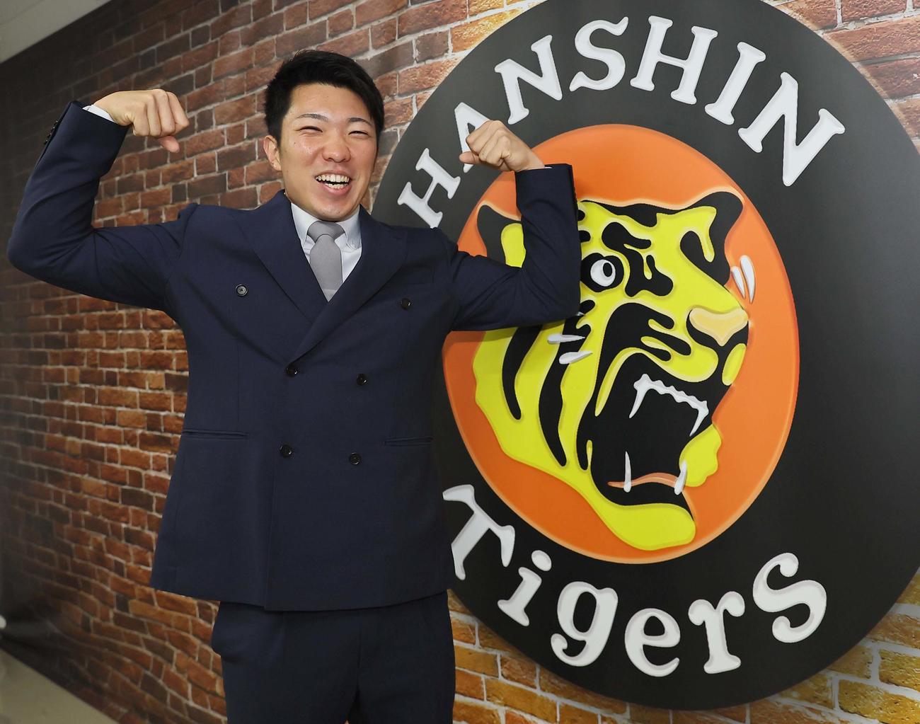 契約更改した石井はマッスルポーズをして笑顔を見せる（撮影・上田博志）