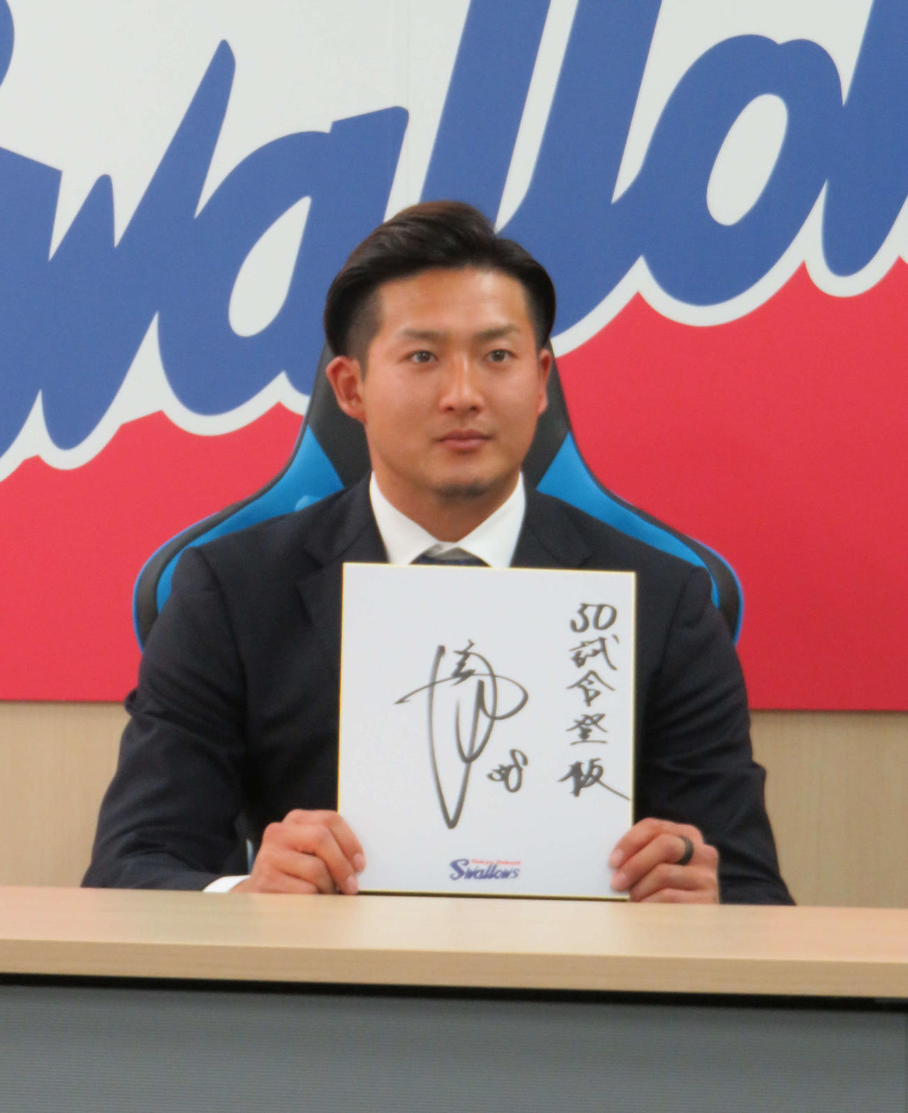 契約更改会見に臨み、色紙に「50試合登板」としたためたヤクルト梅野（2023年12月7日）