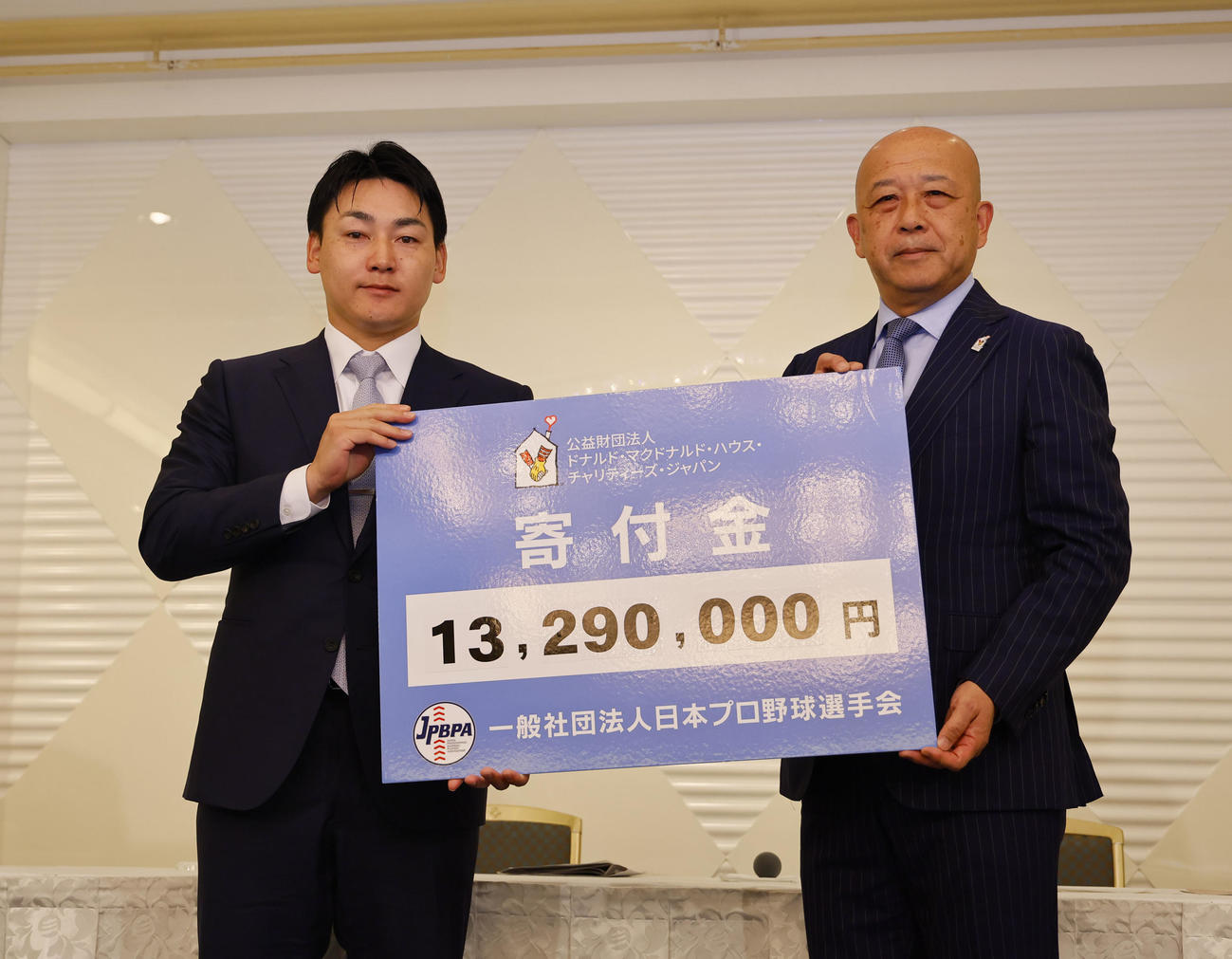 「ドナルド・マクドナルド・ハウス」の支援事業に寄付金を手渡す一般社団法人プロ野球選手会理事長の巨人丸（左）（撮影・藤尾明華）