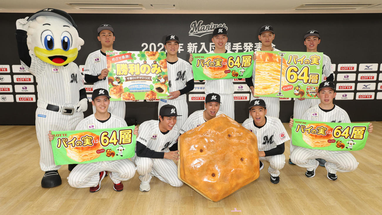 巨大なパイの実を持って記念撮影するロッテ新入団選手たち。前列左からドラフト4位早坂、ドラフト2位大谷、ドラフト1位上田、ドラフト3位木村、ドラフト5位寺地、後列左から育成4位藤田、育成2位松石、育成1位武内、育成3位高野、育成5位富山（撮影・中島郁夫）
