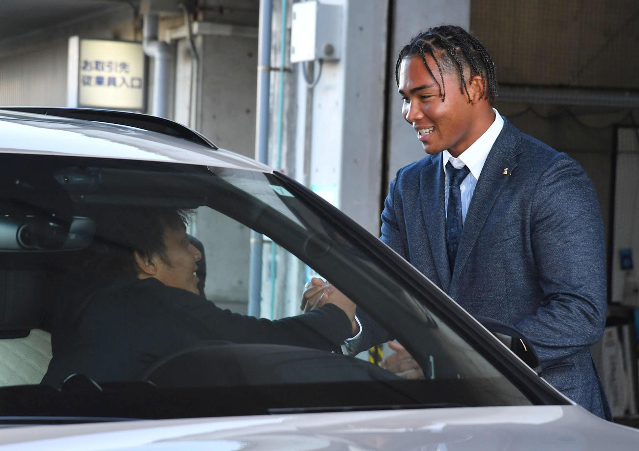 現役ドラフトで日本ハムへ移籍が決まった水谷（右）は今宮と握手を交わす（撮影・岩下翔太）