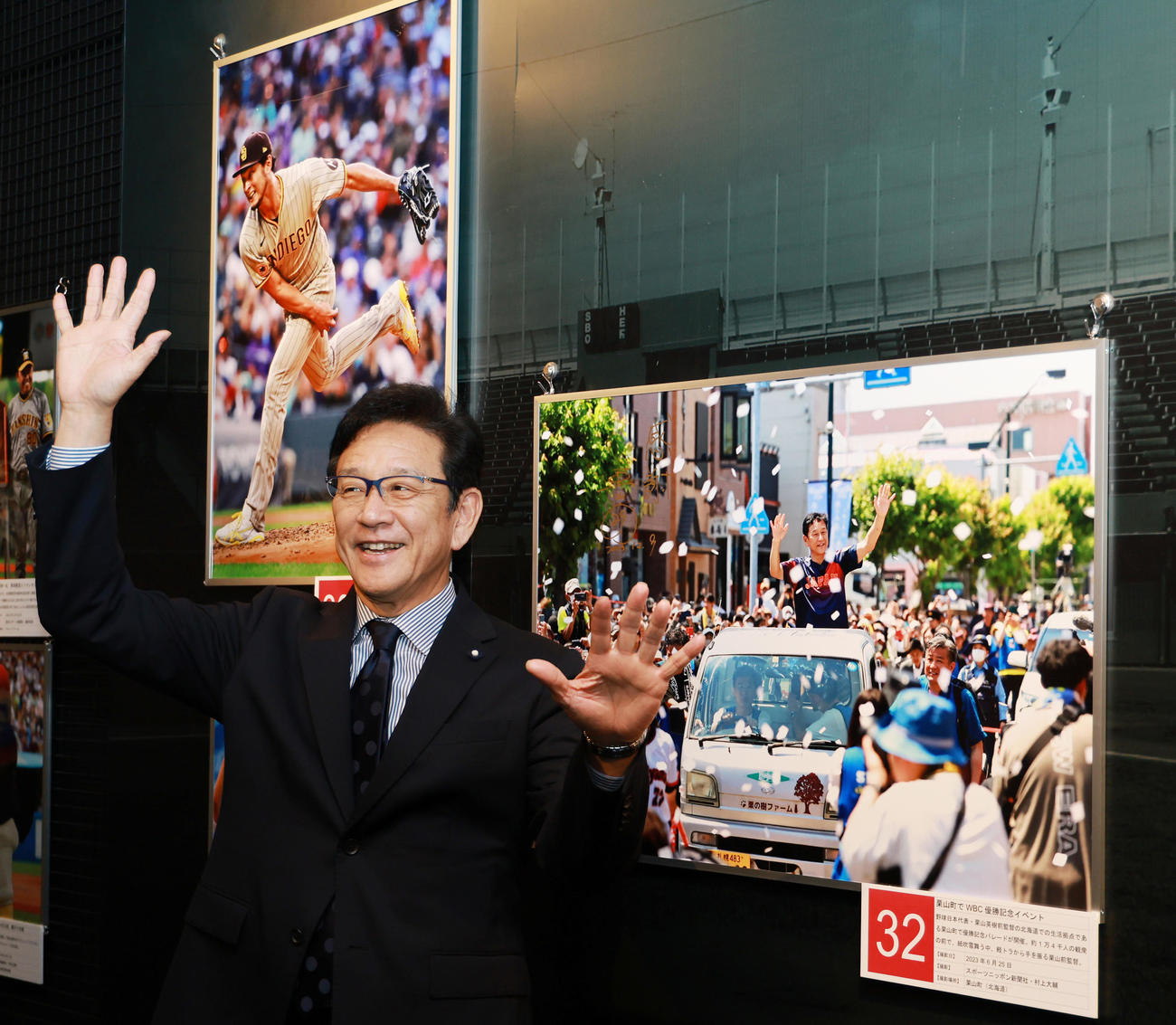 野球殿堂博物館で始まった「野球報道写真展」を訪れ、栗山町でのWBCで優勝パレードの写真の前で、同じポーズを見せる侍ジャパン前監督の栗山氏（撮影・野上伸悟）