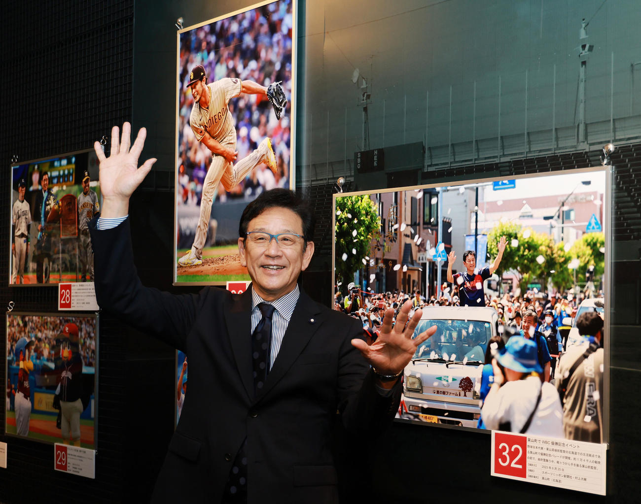 野球殿堂博物館で始まった「野球報道写真展」を訪れ、栗山町でのWBCで優勝パレードの写真の前で、同じポーズを見せる侍ジャパン前監督の栗山氏（撮影・野上伸悟）