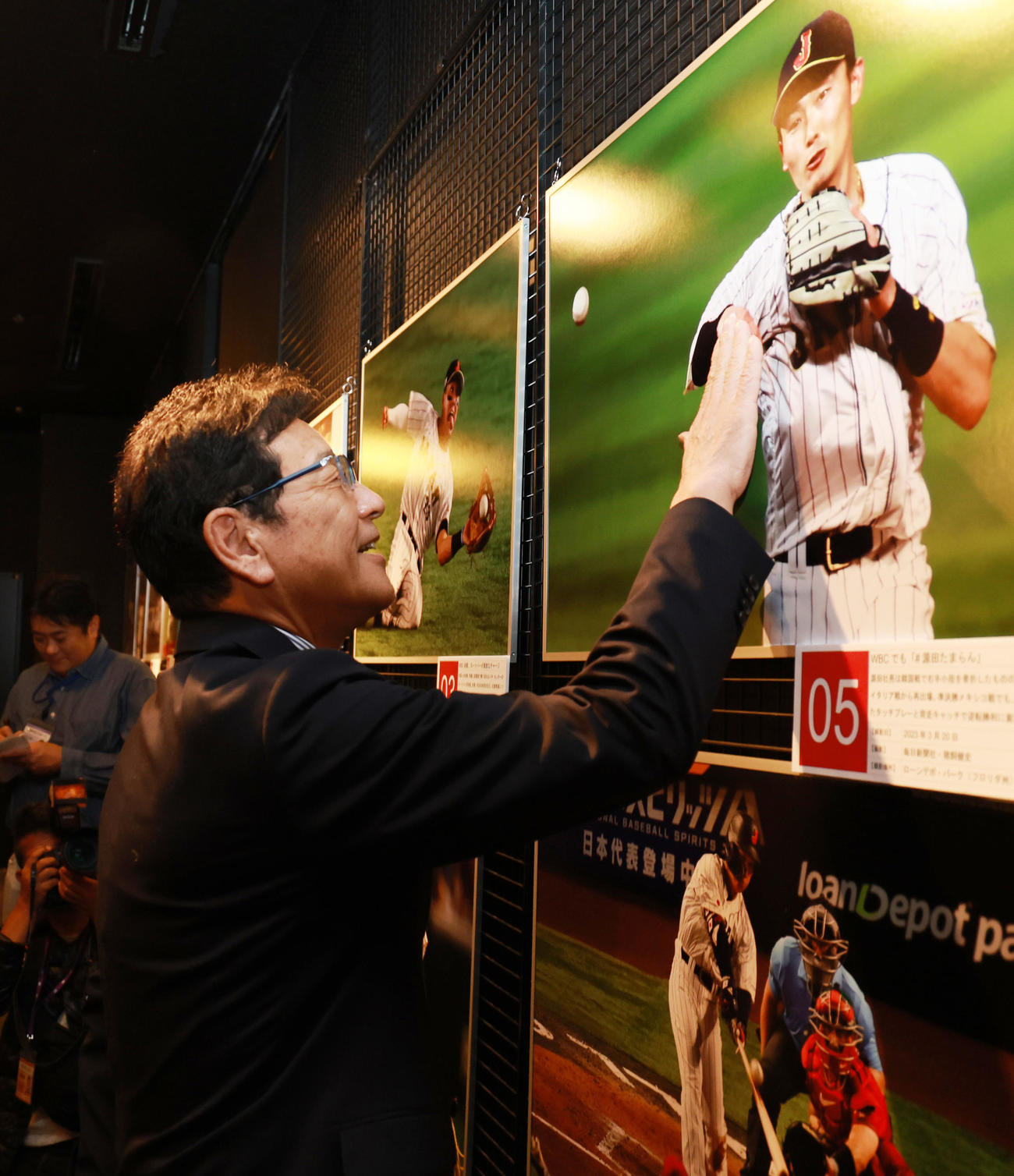 野球殿堂博物館で始まった「野球報道写真展」を訪れた侍ジャパン前監督の栗山氏は、WBCで骨折を押してプレーする源田の写真を見つけると、「源ちゃん、痛かっただろうなあ」と患部を触る（撮影・野上伸悟）