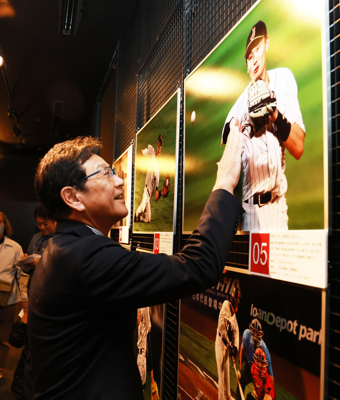 野球殿堂博物館で始まった「野球報道写真展」を訪れた侍ジャパン前監督の栗山氏は、WBCで骨折を押してプレーする源田の写真を見つけると、「源ちゃん、痛かっただろうなあ」と患部を触る（撮影・野上伸悟）