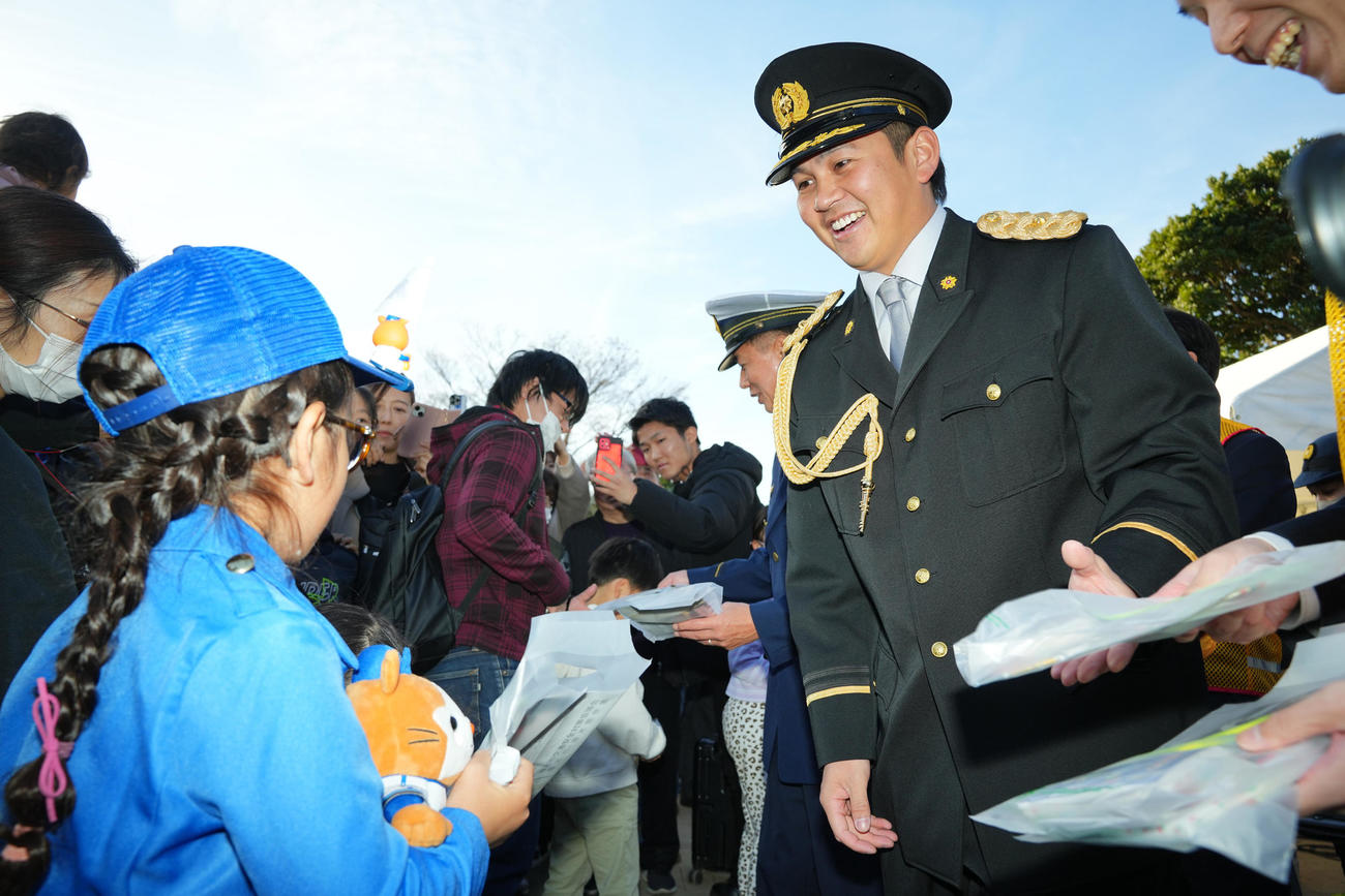 厚木警察署一日署長を務めファンの子どもたちにグッズを配るDeNA山崎（撮影・垰建太）