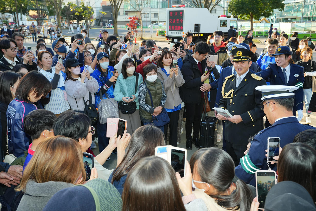 厚木警察署一日署長を務めファンにグッズを配るDeNA山崎（右）（撮影・垰建太）