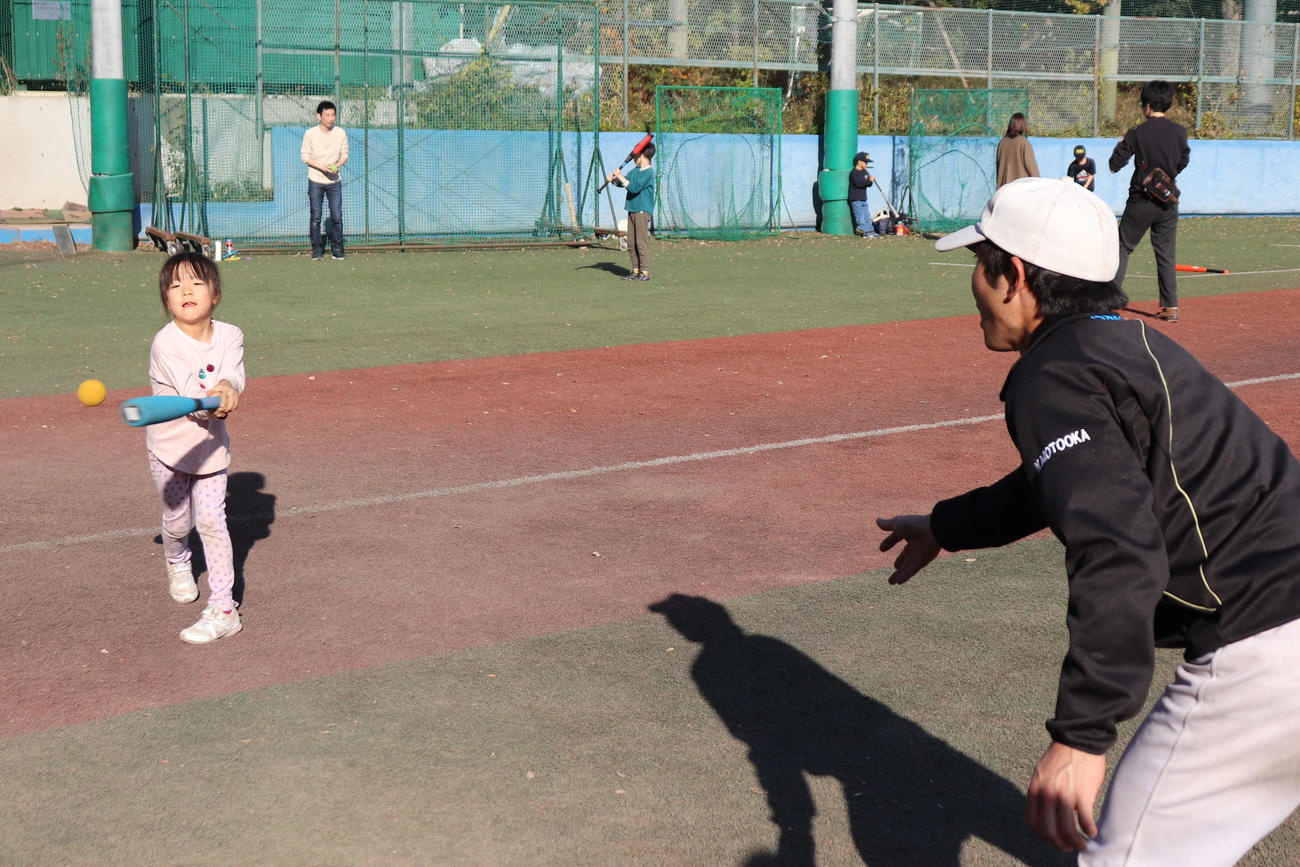 東京6大学野球の社会連携アクション、「野球部グランドを子どもたちの遊び場へ」でグラウンドを開放し、チームが用意したプラスチックのバットとゴムボールで部員と遊ぶ子どもたち（撮影・保坂淑子）