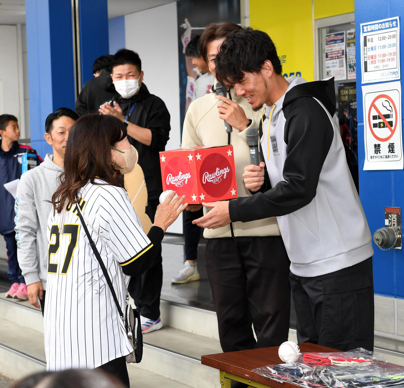 トークショーの抽選会で当選者にプレゼントを手渡す伊藤将（撮影・前岡正明）