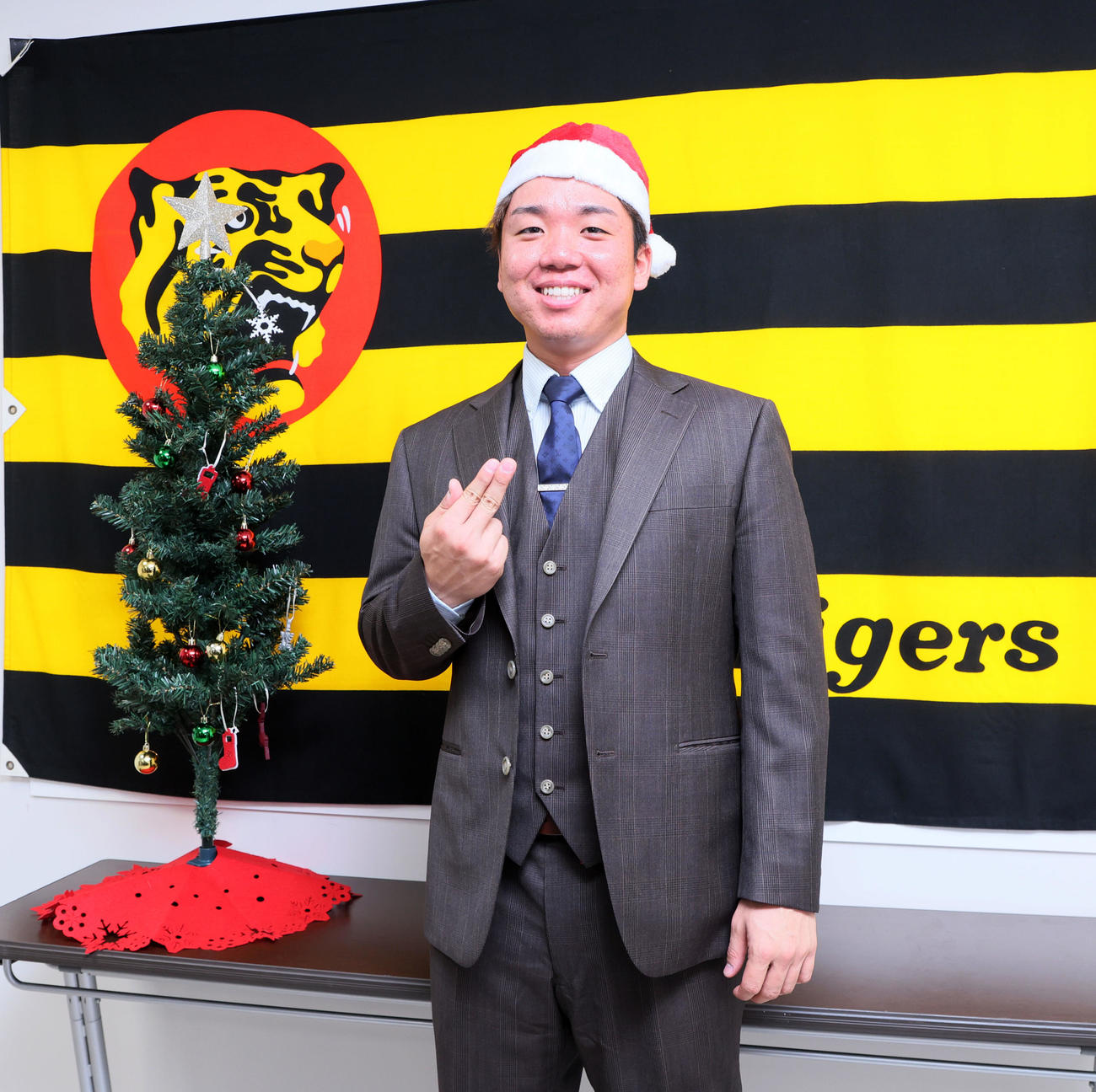 球団史上最高となるアップ率で契約を更改しサンタの帽子をかぶって淡路島ポーズを見せる村上（撮影・加藤哉）