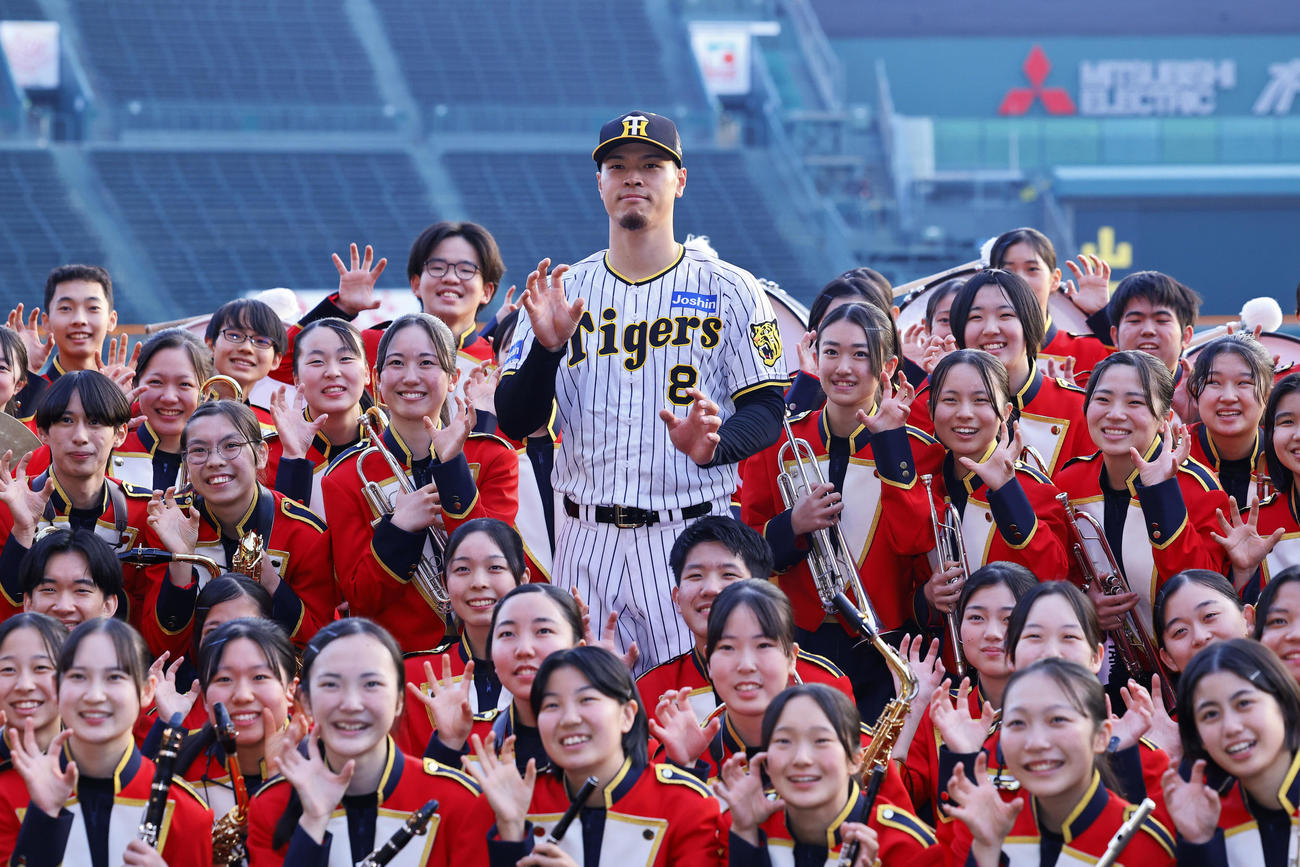 ミズノベースボールドリームカップの表彰式を終え、ブラスバンドの学生と写真に納まる阪神佐藤輝（撮影・藤尾明華）