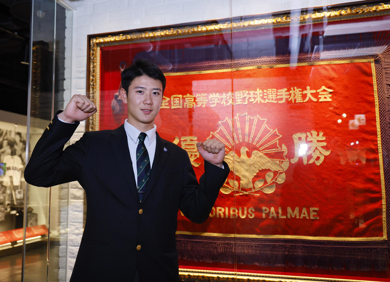 甲子園歴史館で展示されている仙台育英の優勝旗も前でポーズをとる阪神ドラフト3位の山田田（撮影・藤尾明華）