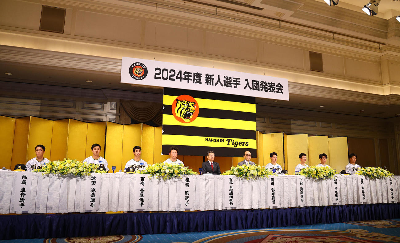 新人選手入団発表で壇上に座る阪神の新人選手ら。中央右は岡田監督（撮影・藤尾明華）
