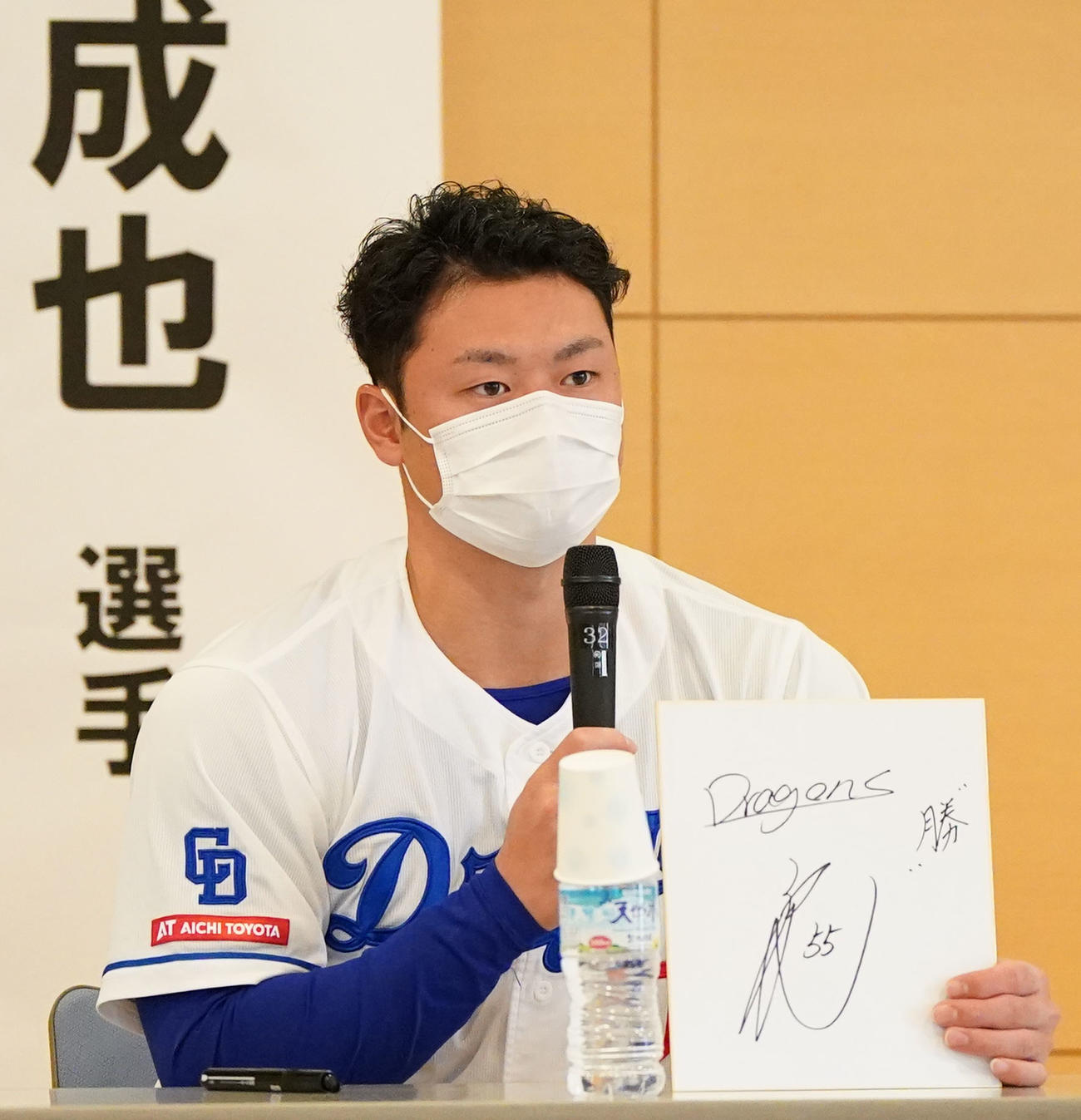 病院を慰問しイベント内で、来季の抱負を漢字一文字で「勝」と新背番号55を色紙に記す細川（撮影・森本幸一）